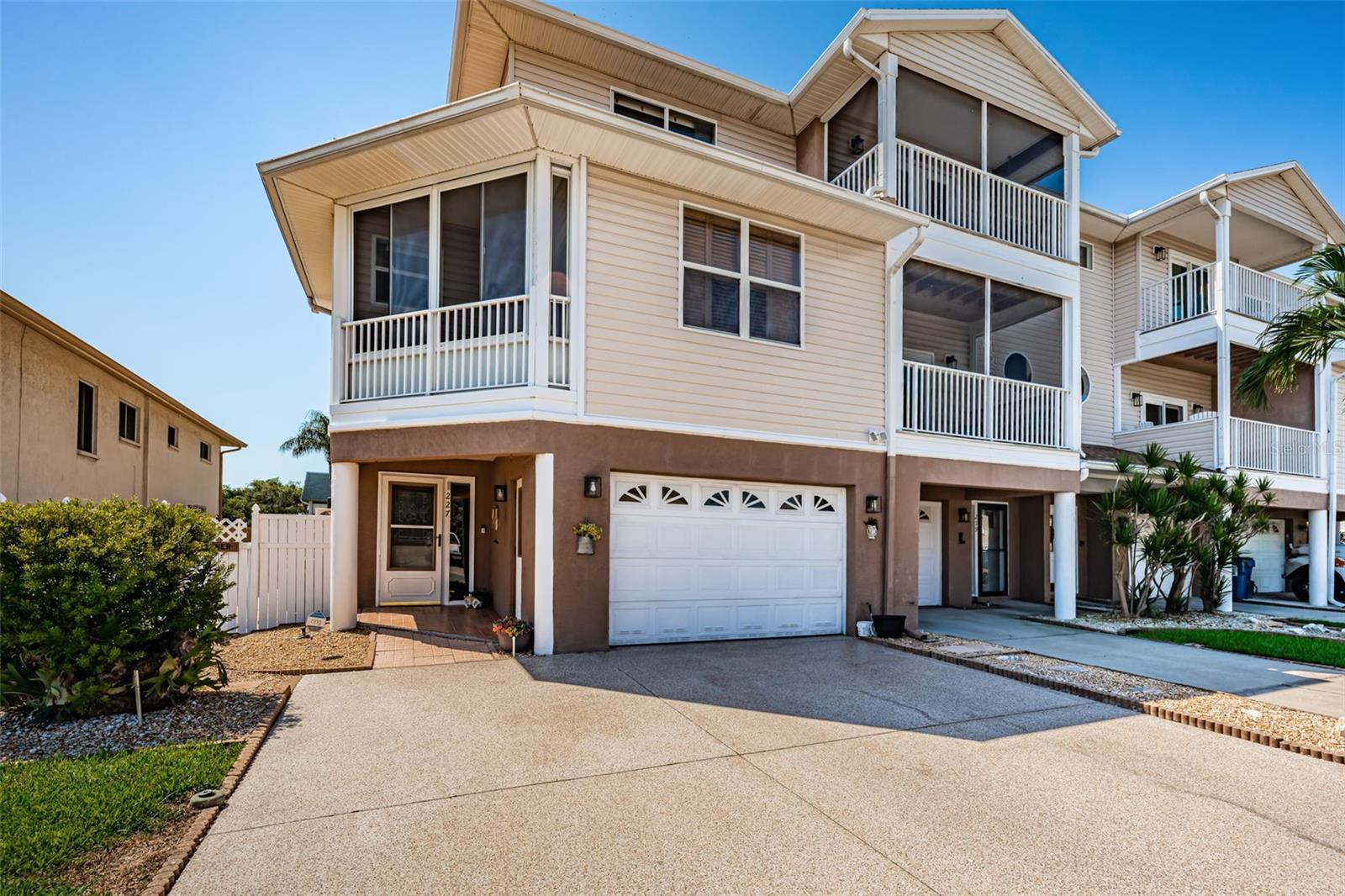 Timeless elegance and thoughtful design define this three-bedroom, two and a half bath townhome in the desirable Isle of Capri community of Treasure Island. From the moment you arrive, the extended epoxy driveway and oversized epoxy garage with side entry create a welcoming first impression, while the corner lot offers added space and privacy. Inside, high ceilings and an expansive living room anchored by a gas fireplace set the stage for relaxed yet refined living. The open kitchen with bar seating and reverse osmosis system blends seamlessly into the living space, making it ideal for everyday gatherings and entertaining. Plantation shutters accent the windows in both the living room and primary suite, where a private screened balcony captures tranquil water views. The primary suite also features a walk-in closet and a spa-like bath with dual vanities, a jetted tub, and a walk-in shower. Upstairs, the guest quarters provide two spacious bedrooms with generous closets and a shared bath with a tub and shower combination, including one bedroom that enjoys a serene water view of the Intracoastal. A custom elevator services every level, while a staircase from the main living area leads to the outdoors where the side yard is designed with rock and steppingstones connecting the front gate to a separate gated backyard. The backyard combines professional pavers with rock gardens around the perimeter, creating an inviting and low-maintenance setting for entertaining or quiet enjoyment. Recent updates include a new water heater in 2025, newer roof in 2022, and HVAC system in 2024. The Isle of Capri community enhances the lifestyle with amenities including tennis and pickleball courts, shuffleboard, a playground, dog park, gazebo, and baseball field, all within walking distance to the Treasure Island Boardwalk and beach, where sugar-sand shores, scenic paths, and local dining await.