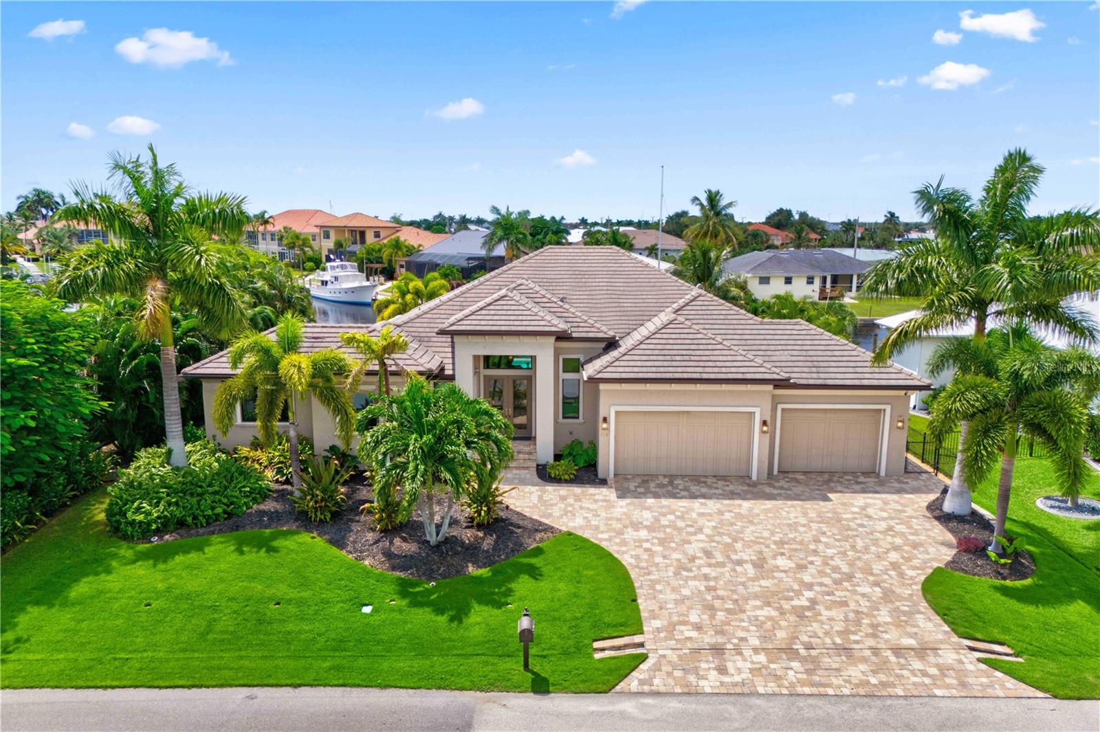 This stunning, custom waterfront smart home defines the ultimate coastal elegant lifestyle. The executive, deep water sailboat lot is surrounded with lush tropical landscaping and located in lovely Punta Gorda Isles. Property is appointed with level-5 features throughout and is designed for the ultimate waterfront living with direct access to Charlotte Harbor in just five minutes. The 90’ dock can accommodate two boats and is outfitted with two Dockmates with 60 AMP power and water, 16,000 pound boat lift that would please a seasoned boater.
The lush grounds, framed by swaying royal palms, a functional garden, LED lighting, and a pet-friendly grass area, offer a stunning first impression and a glimpse of the beauty that awaits inside. The interior offers soaring 10-14' ceilings accented with multi-level tray designs and sleek wood slate ceilings that elevate every room. The open-concept floor plan, complemented by wood and marble flooring, includes a great room with 3 en-suite bedrooms, a den, a bonus room, and 3.5 baths. The chef's kitchen is equipped with a gas range, Wolf, Subzero, Advantium and Bosch appliances, extra large island with prep sink and abundant storage, walk-in pantry, custom cabinetry with multi level ceiling trays with programmable LED lighting with high quality surround sound indoor and outdoor audio speakers and a hidden scullery for seamless entertaining. The primary suite is an ultra-luxurious spa-like retreat with a free-standing waterfall tub, walk-in shower, and dual sinks, creating the perfect escape. The 10' sliders open to the extended lanai, revealing a resort-style oasis with a kitchenette, pool bath, upgraded waterfront heated saltwater pool with sun shelf featuring a negative edge design and spa with waterfall anointed with authentic Hawaiian propane-fueled Tiki torches all perfectly crafted for luxurious outdoor living.
Notable features include A 500-gallon in-ground propane tank fuels the home's whole-house generator, oversized 3-car garage with one bay converted into a workshop, solid wood doors, upgraded molding, custom walk-in closets, and windows adorned with motorized blinds. Modern glass chandeliers,Robern extra deep medicine cabinets with night lighting, Italian quartzite, rare leather-finished granite, marble and wood flooring, Italian plaster tropical relief walls designed by local artist, Diane Kole, in master bath, indoor laundry room with cabinets and wash sink, programmable LED lighting, custom cabinets throughout, micro blind doors 4’x4’ propane fire pit, plumbed propane gas lines for outdoor BBQ. Programmable sprinkler system, garden and pool lighting, functional landscape garden with a variety of citrus trees, herbs and tropical fruit.
Minutes away from historic Punta Gorda, shops, restaurants, art galleries, Fisherman’s village, fishing piers, waterfront parks, boat ramps, rentals, tennis and pickleball courts, weekend farmers markets and craft fares, and much more.