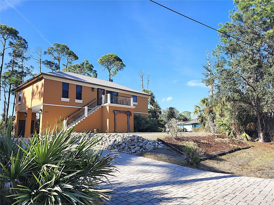 Beautiful Custom Built 2 Bed 2 Bath with a Den or possible 3rd Bedroom. This home has been beautifully designed with attention to detail. As you drive up to the property you will notice the 45 foot brick paver driveway that is leveled off, perfect for the Motor Home or RV(home offers water and electric hook ups).  As you enter the home you will notice the gorgeous arches, high ceilings, canned lighting throughout, solid wood core doors, crown molding, pocket doors, brand new vinyl plank flooring through the entire home. Home is pre-wired for central vacuum, Impact windows and sliders in all rooms. The front screen door is locking and Impact Resistant.  Spray Foam Insulation throughout the home and allows for low utility bills and keeps an even temp in the home. The living room is large and is adorned in crown molding and new flooring. The kitchen offers granite counters, solid wood maple cabinets with wired under mount lighting, new faucets and shut off valves, pendant and canned lighting, breakfast bar, large stainless steel sink with separate sink that has the disposal. The owner’s suite offers a large room with private sliders to the 12x30 rear deck, crown molding, new floors, en suite offers dual sinks with new faucets and shut off valves, walk in shower with dual heads, soaking tub and walk-in closet with attic access for extra storage. The second bedroom is very roomy and has new flooring as well. Guest bathroom is large in size and has granite tops, new faucets and shut off valves and a walk in shower. The Den or 3rd Bedroom is adorned with crown molding and large in size. The rear deck is 12x30, shaded in the mornings, has new trex decking, wood stairs and allows for beautiful sunset evenings. There is a large storage area in the parking garage, A 500 gallon rain barrel is connected to the gutter system, new a/c unit, metal roof, there is parking for up to 6 vehicles or you could potentially enclose for more useable space with proper permitting. Possibilities are endless and this may be good for a business set up or someone who owns a lot of cars. Home sits on 4 lots that total almost a full acre of land. Plenty of room to add a designer pool.  Owner has another 4 other lots that can be purchased also to combine with this home. This is a one owner home and has been well cared for. Home is not in a flood zone! You can be to some of the best beaches Florida has to offer within 35 minutes. Close to medical, shopping,dining, entertainment and more.