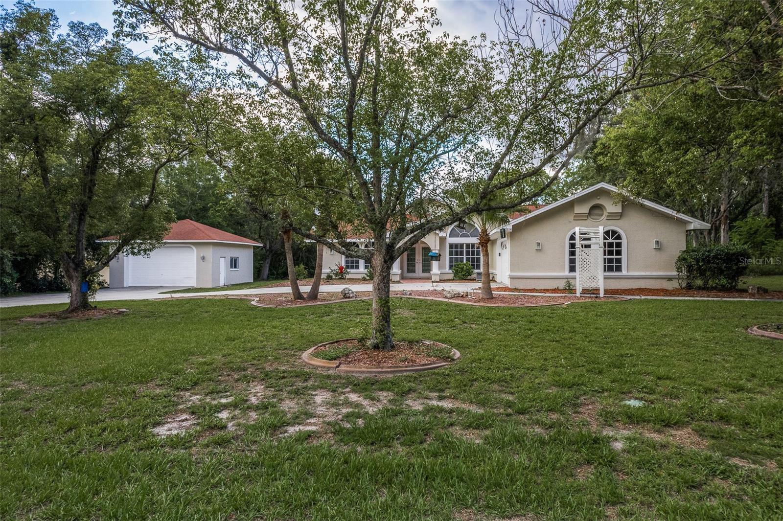Welcome home to your generously updated 3 bedroom 2 bath pool home situated on an acre and a third in the highly desirable community of Woodland Waters. Room to breathe inside and out with plenty of room for your toys This home features an attached two car garage for your daily drivers and a large 24x24 detached garage ready to be filled with your dreams. Inside enjoy a totally open concept kitchen with quartz countertops. stainless steel appliances, huge breakfast bar and nook overlooking the pool area. The kitchen overlooks the formal dining area and large family room with wood burning fireplace and view of the back yard. The primary bedroom features two walk-in closets and an enormous bath with a walk-in shower, his and hers sinks, and a vanity area. The backyard features a covered patio and screened in-ground pool with a cooking area. Roof and A/C both installed in 2017/2018. Close to everything the Florida lifestyle has to offer while allowing the ability to stretch your feet.