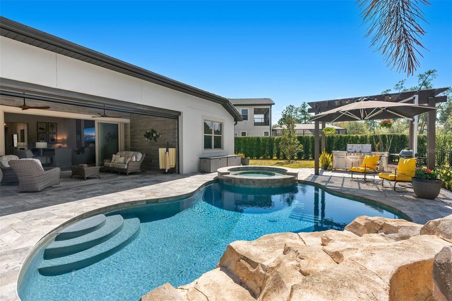 Welcome to 10588 Royal Cypress Way, a professionally designed luxury retreat in the highly sought-after Royal Cypress Preserve—one of the most exclusive gated communities near Walt Disney World Orlando, The Four Seasons, and Golden Oak. Perfectly positioned for privacy, breathtaking sunsets, and nightly views of Disney fireworks, this exceptional home offers a rare blend of elegance, comfort, and resort-style living on a single story Massiano floor plan that suits every phase of life.

From the moment you enter, you’ll notice the home’s intentional design and thoughtful upgrades, and soaring ceilings, including wood-look tile flooring throughout, upgraded  designer lighting, and elevated finishes that create a warm, sophisticated atmosphere. The heart of the home is a stunning chef’s kitchen featuring upgraded floor to ceiling cabinetry, premium appliances, and a built-in wine refrigerator—perfect for entertaining in style.
Step outside and discover your own serene backyard oasis, designed for year-round enjoyment. Take in the peaceful preserve backdrop as you relax in the outdoor living space with a built-in fireplace, heated pool and spa, or host unforgettable evenings under the pergola in the outdoor grilling area. With no rear neighbors and tranquil views, this outdoor space feels like a private resort—right at home.

Located just minutes from world-class dining on restaurant row, shopping, and Orlando’s top attractions, Royal Cypress Preserve is known for its luxury lifestyle, prime location, and elevated community feel. Come and enjoy the private community dock overlooking South Lake’s skiable waters via boat, jet skis, kayak, or paddle board. Owners experience resort-style low maintenance living in this private 24-hour guard-gated enclave of only 206 homes that features a stunning clubhouse with a zero-entry sparkling pool and fitness center overlooking the pristine 124-acre South Lake with landscape maintenance included in the HOA. This is more than a home- it’s a destination!