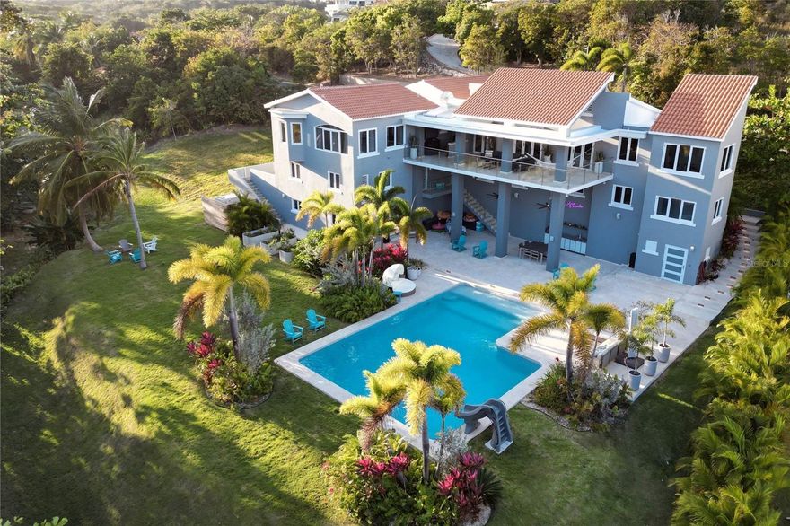 Looking for the ultimate luxury retreat? Look no further than this magnificent contemporary home located in the world-renowned Palmas del Mar resort in Humacao on the east coast of Puerto Rico.

This stunning 6,011 sqft home boasts 5 spacious bedrooms and 7 luxurious bathrooms, providing ample space for you and your guests to relax and unwind. The main living area features an additional 700 sqft covered deck with breathtaking ocean views, perfect for hosting gatherings and enjoying the stunning natural beauty that surrounds this gem.

Step outside and discover your own private resort-style pool (41’x27’) set on a beautifully landscaped 1,845 m2 parcel of flat, usable land. The outdoor living space includes a 2,500 sqft patio with wet bar, prewired and plumbed for a pool house, as well as a vegetable garden for all your culinary needs.

The property also features a 2-story guest apartment with a 2nd kitchen and separate entrance, providing a rentable income stream or extra space for guests.

But that's not all – just steps away from your front door, you'll find the secluded Shell Castle beach, where you can relax in peace and soak up the sun.

For added peace of mind, the property comes equipped with a new 30kw generator and transfer switch, as well as state-of-the-art security features including cameras, alarms, lighting control, landscape lighting, and irrigation.

Looking to expand your property even further? The adjoining lot (24) is also available for sale, providing an additional 1,181.24 m2 of space for whatever your heart desires, whether it's additional outdoor living space or your very own private tennis court. The lot is priced at $275,000, making it a steal for any savvy investor.

And best of all, this property is located within the world-renowned Palmas del Mar resort, which boasts a plethora of world-class amenities, including miles of coast, golf cart paths, two championship golf courses, tennis courts, pickleball courts, an equestrian center, beach club, a Pterocarpus forest, restaurants, shops, bank, churches, supermarket, professional services, and a private PK-12 college prep school. Imagine driving to school in a golf cart – it doesn't get any cooler than that!

Don't miss out on this once-in-a-lifetime opportunity to own your very own piece of paradise in the heart of Puerto Rico. Schedule a viewing today and start living the luxury lifestyle you've always dreamed of.