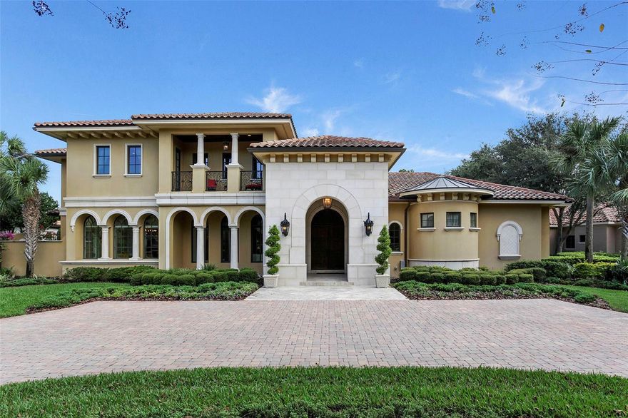 Experience the ultimate in architecture and design in this grand two-story estate overlooking beautiful water and conservation views within the gated community of Lake Nona Golf & Country Club. Enhanced both inside and out by the finest finishes, the home encompasses more than 10,000 square feet of interior and exterior living space. Enjoy the rich details of this sophisticated residence throughout the interior, from French entry doors, chiseled-edge travertine and tile to stone column accents and hand-textured wall treatments. The home evokes pure elegance, which is perhaps best captured in the dramatic two-story stair hall that joins the formal living and dining rooms to the kitchen and family room. Highlights of these primary living spaces also include a soaring ceiling and fireplace in the formal living room and a well-appointed Butler’s pantry and private courtyard outside the dining room. Indulge in Florida’s year-round temperate climate in the expansive outdoor living area, featuring a covered lanai with fireplace and summer kitchen. Surrounded by a lovely colonnade with Gazebo, the screened area also offers a custom heated pool and spa are further accented by a fountain and waterfall. Additional features include a an owner’s suite with vestibule, morning bar, walk-in closet, Jacuzzi tub and separate walk-in shower, a theater with projector screen and full wet bar and a three-car garage.