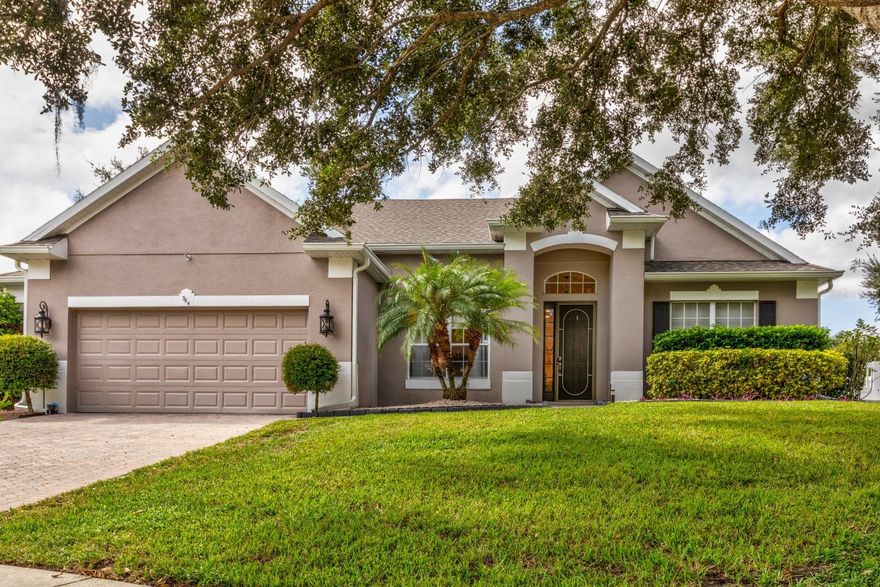 Eustis beauty nestled on a serene corner in the sought-after gated community of Blue Lake estates. This home offers tranquil living plus subtle lake views with unbeatable convenience-just minutes from shopping, dining, hospitals, top-rated schools and neighboring city of Mount Dora. Step through the dramatic entryway of cherrywood flooring and discover a thoughtful layout: a private office to the right, adjacent full bath, formal dining to the left, and an open concept living space with 12 ft ceilings throughout that flows seamlessly to the expanded covered porch-blurring the line between indoor comfort and outdoor charm. The lush, landscaped back and side yard is completely fenced adding to privacy, enjoyment and security for pets and young ones. The spacious primary suite is a true retreat, featuring a luxurious en-suite bath with dual vanities, a soaking tub, separate shower, and 2 generous walk-in closets. The split bedroom design ensures privacy, with 2 additional bedrooms, a shared bath and flex space to suit your needs-additional bedroom, hobby spot, home gym, or more living area. Lots of closet and linen space here, in fact the entire home has tons of storage. The kitchen is a chef’s delight, boasting a center Island, breakfast bar, eat in nook, and a layout that invites cooking and connection. A two-car garage includes a fan and handy bump-out—perfect for even more storage, a workbench or extra fridge. Need more storage? The attic is fully floored! This home has been immaculately maintained with new roof Sept 2021, HVAC May 2019, Hot Water Heater and so many improvements and updates. Such as Interior and Exterior Paint, Digital Networking Center, 21 new Can Lights, Custom Pantry, Plantation Shutters and so much more. Priced to sell below market value…Rush to view!