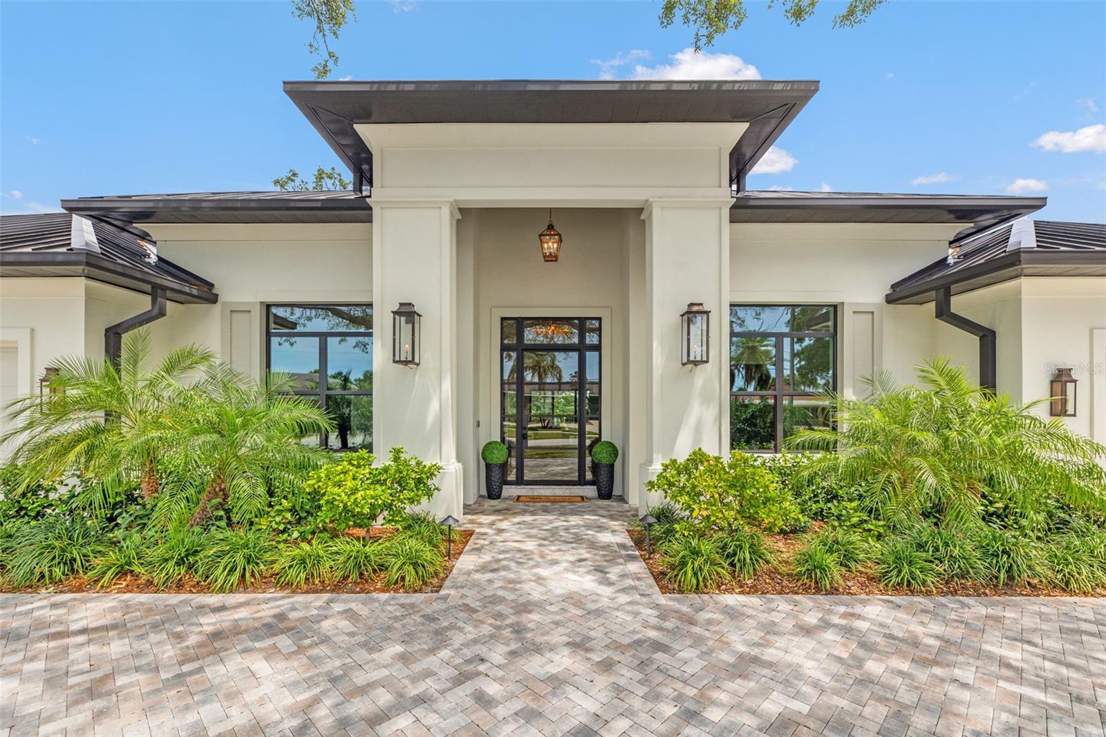 Move straight into an untouched masterpiece overlooking the 5th fairway of the prestigious Pelican Golf Club, widely regarded as Pinellas County’s finest private course. Completed in 2024 and never occupied, this executive residence pairs crisp modern architecture with warm, livable spaces, creating an ideal setting for everyday comfort, grand entertaining, and multigenerational living. A dramatic great room welcomes you with oak floors, 14-foot coffered ceilings, and an entire wall of glass that frames manicured fairways and bathes the interior in natural light. The adjacent chef’s kitchen is a true showpiece, anchored by dual center islands, bespoke cabinetry, dramatic marble countertops, Kraus workstation sinks, Waterworks fixtures, and professional-grade appliances that are equally suited to casual breakfasts or catered soirées, while the open dining and living areas flow seamlessly to the outdoors through hurricane-rated sliders. The primary suite is a private sanctuary with two generous walk-in closets and a spa-inspired bath featuring dual oversized rain shower heads, a deep soaking tub, and dual vanities with a dedicated cosmetics station. A split-bedroom layout ensures privacy for family and guests, and a versatile bonus room can serve as an executive study, formal dining room, or fifth bedroom. Everyday convenience is elevated by two full sets of washers and dryers in the interior laundry room, and climate-controlled storage in the oversized two-car garage; a separate air-conditioned single garage, about 375 square feet, that can easily accommodate a third vehicle or golf cart. Outback, resort living awaits: a salt-water pool and spa, motorized retractable screens, and a gas fireplace create an effortless venue for sunset cocktails beside the fairway. A 26kW whole-house generator, concrete-block construction, impact glass, and high-efficiency HVAC deliver peace of mind and low operating costs. Minutes from Clearwater’s beaches, marinas, and dining—yet worlds away in privacy and prestige, this brand-new residence offers flawless finishes, cutting-edge systems, and an unrivaled golf-course backdrop. Virtual tour and floor plans are available upon request.