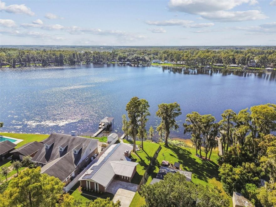 Welcome to 18720 Arbor Drive, a rare lakefront gem nestled in the heart of Lutz on a private, dead-end street lined with newer development. This charming 3-bedroom, 2-bath home offers the perfect blend of tranquility, comfort, and access to Lake Wilson/ Lake Thomas, a spring-fed, motorized ski lake that allows boating, fishing, and water sports. Enjoy your own private boat ramp, a truly uncommon feature, along with a brand-new composite dock and new boat lift, making it effortless to launch, store, and enjoy your watercraft. The kitchen has been thoughtfully renovated, offering extra storage space and an oversized island perfect to host and entertain. The metal roof provides peace of mind for years to come, and the home is also equipped with solar panels for energy efficiency. Inside, you’ll find a cozy wood-burning fireplace, adding warmth and charm to your living space. Start your mornings with coffee as the sun rises over the water, and unwind in the evenings with sunset views from your Florida room. Ideally located just off Dale Mabry Highway, you’ll enjoy quick access to the Veterans Expressway, making it easy to get anywhere in the Tampa Bay area—including Tampa International Airport and the Gulf beaches—all within 40 minutes. One of the most unique aspects of this property is the private trail connecting Arbor Drive directly to Publix, blending the feel of secluded lakefront living with everyday convenience. Best of all, there’s NO HOA, NO CDD, and NO deed restrictions, giving you the freedom to enjoy your property your way. The neighborhood also comes to life with a sense of community during the unofficial annual Holiday boat parade and Fourth of July fireworks display hosted right on the lake. Don’t miss your chance to own this incredible lakefront property at a priced-to-sell listing—paradise truly does exist, and it’s right here on Arbor Drive.