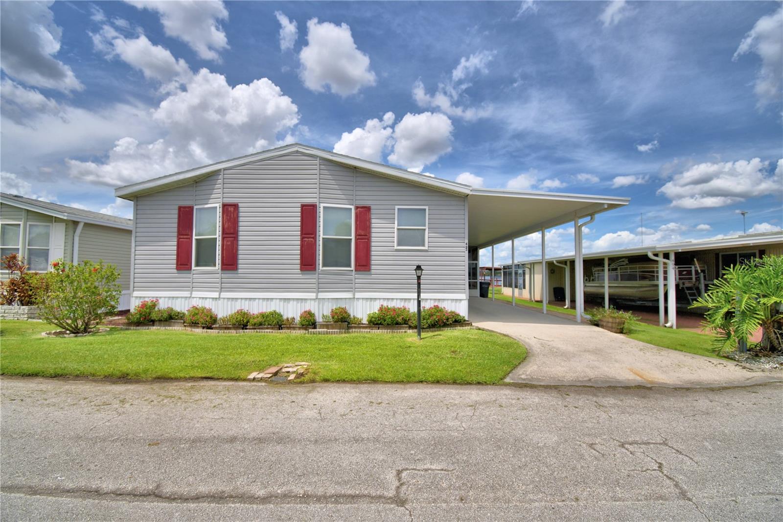 LAKEFRONT LIVING...Why pay lot rent when you can enjoy the charm and tranquility in this beautifully renovated, fully furnished 2 Bedroom/ 2 Bath home in Winter Haven! Nestled in the serene, gated 55+ Lakeside Ranch community on Lake Henry. This home is move-in ready and offers a host of modern updates, including New HVAC (2025) and New Roof and All New Windows both replaced in 2024. The home features a spacious living room, a primary bedroom with an ensuite bathroom and walk-in shower, an indoor utility room with laundry and extra storage, and a screened-in porch perfect for relaxing or enjoying breathtaking sunset views. The kitchen is designed for convenience featuring an Island with Breakfast Bar and ample storage. The carport doubles as additional seating or parking space. Lakeside Ranch is a co-op community where the price includes an $11,000 share in the corporation—meaning no lot rent. The low monthly HOA fee covers water, sewer & garbage. This vibrant community offers an array of amenities, including a clubhouse, heated swimming pool, library, shuffleboard courts, horseshoe area, billiards, a boat launch, and docks on Lake Henry. Residents can also take advantage of scheduled holiday events, arts and crafts classes, exercise programs, card games, and more. For added convenience, the community has a trailer storage area, self-contained water and sewer systems with backup generators. Perfect for year-round residents or snowbirds. Lakeside Ranch Community offers the flexibility to be as active or as relaxed as you desire. With its idyllic location near shopping, dining, and amusement parks, this home offers the best of Florida living. Call today for a private showing and start enjoying the security, serenity, and vibrant lifestyle of this remarkable lakeside community!!