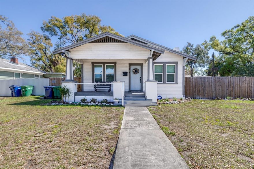 Welcome to 5503 N 9th St, a beautifully remodeled 1925 Craftsman bungalow located in the heart of Tampa. This 2-bedroom, 2-bath home perfectly blends historic character with modern convenience. Relax and unwind on the inviting front porch, the perfect spot for morning coffee or evening downtime. Inside, you’ll find a spacious living area featuring a cozy fireplace, original built-ins, and stunning wood floors and trim that showcase its classic character. An abundance of windows fills the home with natural light, creating a warm and inviting atmosphere throughout. The updated kitchen is a chef’s dream, complete with shaker soft-close cabinetry, stainless steel appliances, marble countertops, a range hood, and a center island—ideal for both everyday living and entertaining. French doors lead into the dining area, creating an open yet defined and inviting layout. The primary suite offers a private retreat with an ensuite bathroom featuring a double vanity and walk-in shower. The second bathroom showcases timeless character with a clawfoot tub and decorative tile.
Major upgrades include new roof fascia and trim (2025), new back door (2025), new fencing (2025), tankless water heater (2022), and AC (2019). New impact-resistant PGT windows have been installed in the living room, primary bedroom, and guest bedroom providing both style and peace of mind. Situated on a desirable corner lot, the fully fenced backyard offers ample space to create your own outdoor oasis, complete with an enclosed back porch and a designated parking area. A laundry room is conveniently located on the enclosed back porch.
Enjoy being just minutes from Downtown Tampa, with quick access to Interstate 275 for an easy commute. Conveniently located near Lake Roberta, dining, shopping, and all that Tampa has to offer. This home is the perfect combination of charm, updates, and location. Don’t miss your opportunity to own a piece of Tampa history!!