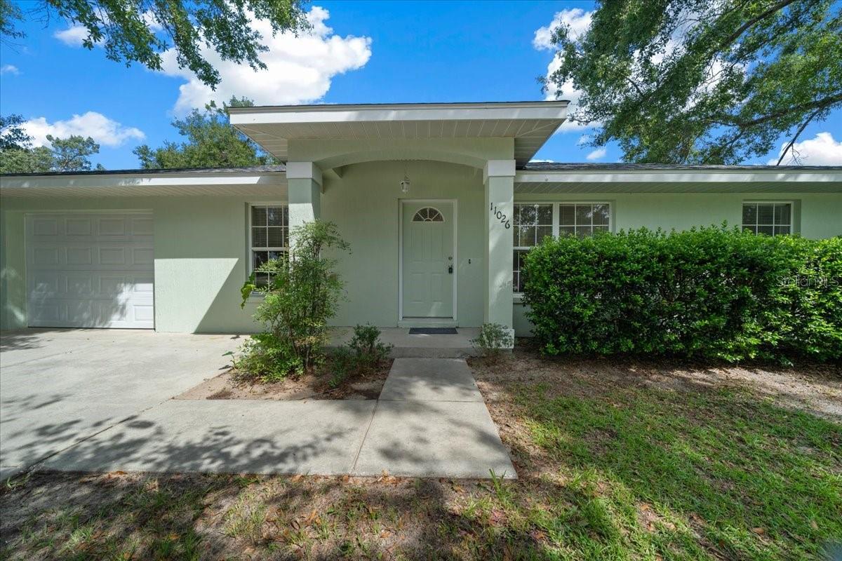 Spectacular location! Just around the corner from Lake Lillian and Belleview’s event-filled city park, this 3-bedroom, 2-bath home sits on a spacious fenced lot and offers recent updates with major improvements already complete. The roof was replaced in April 2025, interior and exterior paint was completed in July, and the A/C system was installed in 2020. Inside, vaulted ceilings and oversized windows bring natural light into the main living space. The dining area opens to the backyard through sliding glass doors, while the galley kitchen offers tile flooring, neutral cabinetry, and backyard views. A walk-in closet and private bath complete the primary suite, with 2 additional bedrooms and a second full bath located on the opposite side of the home. An extra-deep garage includes laundry hookups and access to the backyard. Outside, the fully enclosed yard offers shade, space, and privacy, with a small patio, room to add a garden or fire pit, and plenty of space for pets to play. The location is one of the best in Belleview, just a short stroll to Lake Lillian and the city’s central park, where festivals, concerts, and community events are held year-round. Restaurants, schools, and shopping are close at hand, with quick routes to both Ocala and The Villages.
