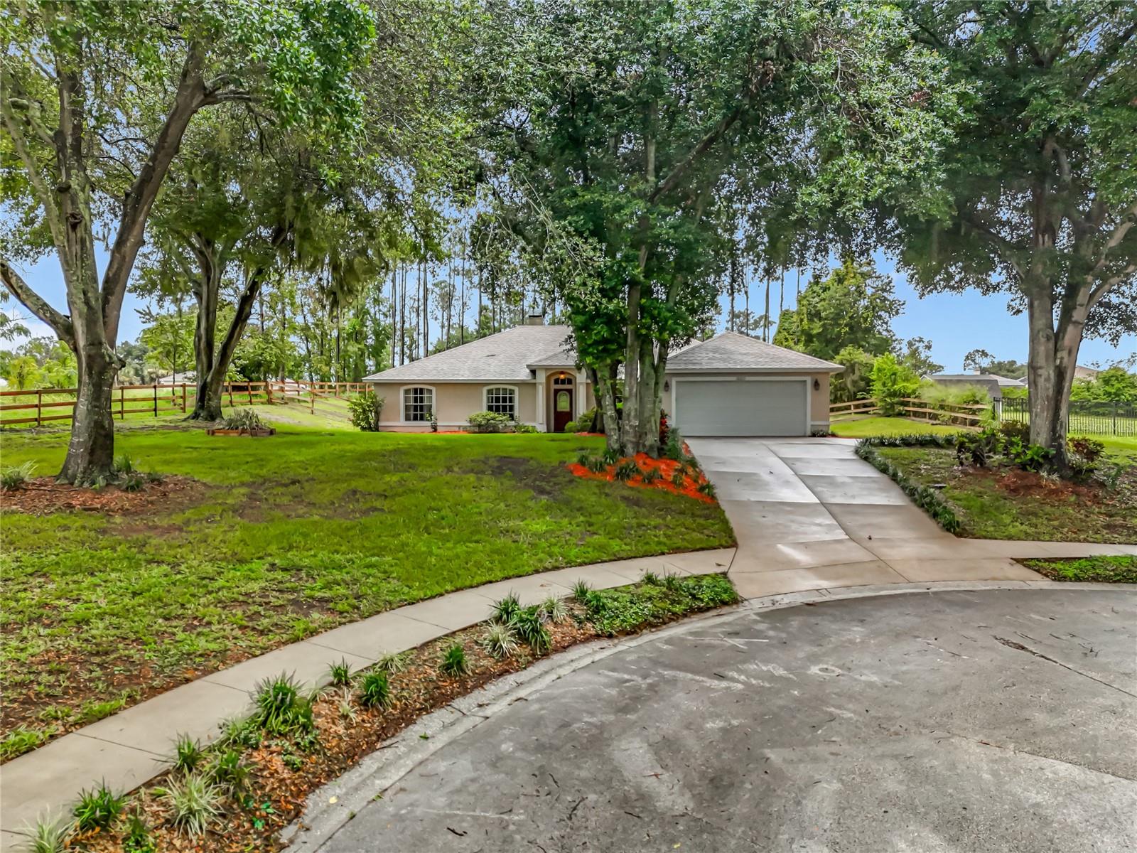 Under contract-accepting backup offers. One or more photo(s) has been virtually staged. This charming 3-bedroom, 2-bath home overlooking beautiful Lake Apopka sits on a generous .74-acre oversized lot and is tucked away on a quiet cul-de-sac, This home offers the perfect blend of comfort, space, and natural beauty. Step inside to find a split-bedroom floor plan with versatile living areas, including a separate living room- ideal as a home office- and a formal dining room for gatherings. The large family room features a cozy wood-burning fireplace, perfect for cool Florida evenings. The kitchen has stunning maple cabinets topped with crown molding, a breakfast bar, large pantry, and a eating nook that offers amazing views of the expansive backyard. A new microwave was added in 2023. The primary suite is located just off the kitchen and features French Doors that lead to the patio and boasts an ensuite bath with a seperate shower, garden tub, dual vanities, and two walk-in closets plus a storage closet. Two additional bedrooms and a full bath are privately located on the opposite side of the home. The laundry room is conveniently located between the kitchen and the garage The 2 car garage has pull down stairs for easy access to attic storage. Enjoy outdoor living year-round with a screened and covered patio, and let your imagination roam on the oversized lot with plenty of room for a pool, garden, or playground. Recent updates include Carpet (2018), AC (2020), Roof (2021), Water Heater (2022), Drainfield (2024). Located near Kirk Park which includes a dog park, Truskett Park, and Lake Florence Park with fishing pier access. Walk to Lake Apopka and enjoy serene wildlife views daily. Just minutes from Montverde Academy, restaurants, shops and more- This is your opportunity to enjoy peaceful rural living with city convenience.