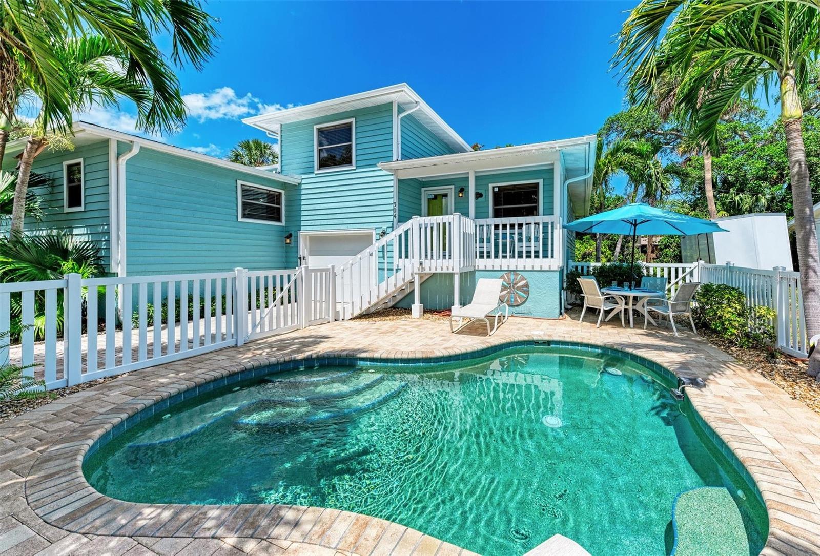 This 2 bed/2 bath picture perfect island dream is ideally situated on a quiet street, just two short blocks from the Gulf Beaches! Elevated, with a private pool and your own garage, you will enjoy relaxing surrounded by coastal charm. The updated, open kitchen with quartz counters, is equipped with stainless steel appliances and ample shaker style white cabinetry. Your guests will enjoy their first floor accommodations with easy access to the updated bathroom with white subway tile surround and updated vanity with Moen faucet. The luxury vinyl large plank flooring throughout is ideal for beach living, and ties the open living and dining room together. Upstairs you will relish the privacy of your primary retreat. The sunlight brightens your spacious room that includes a walk in closet. And your en suite bath has a glass enclosed shower, with tile bench and pebble stone shower flooring. And outdoors, you can relax on your front porch, or cool off in your own pool! Embrace the island life in this lovely land condo, and use it as a short term rental when you are away.