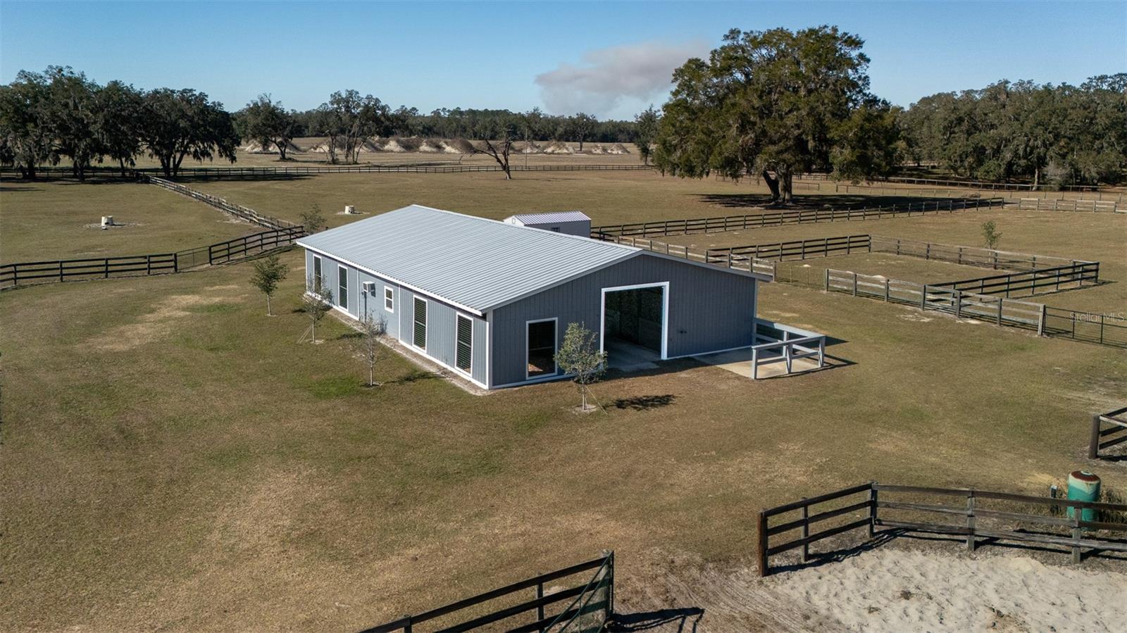 Located in the peaceful countryside of Ocala, this 20.09-acre fully fenced property offers the perfect balance of tranquility and proximity to world-class equestrian venues. Just 10 minutes from both the World Equestrian Center and HITS, this farm provides easy access to top-tier competitions while maintaining a serene, quiet setting for you and your horses. The property features a well-maintained 8-stall center-aisle barn with a sturdy wood frame construction. Designed with practicality in mind, the barn includes a barn office, bathroom, tack room, wash rack, and feeding stations, ensuring a smooth daily operation for your equine care. Additionally, a separate storage shed provides extra space for equipment, hay, or other supplies. With six established paddocks and two turnout pens, there’s ample space for turnout, training, and grazing, all surrounded by mature oak trees that offer natural shade and add to the picturesque beauty of the land. Plus, there is plenty of room for constructing an arena to further enhance the property's equestrian potential. This property offers a combination of location, quiet surroundings, and exceptional equestrian amenities!