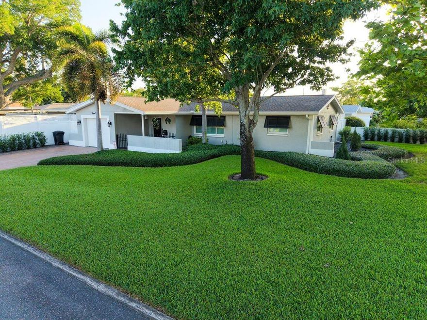 Look no further, your dream home awaits! Located in a non-flood zone in the heart of north St. Pete, this gorgeous 3 bed 2 bath home is situated on an oversized corner lot surround by meticulous landscaping. With an open layout yet coves of privacy, this property has it all from tasteful updates throughout, outdoor entertainment space and plenty of room for storage including a boat or RV! As you follow the pavers through the front gate and covered front entry, you're greeted with industrial laminate floors, cedar wood shiplap walls, crown molding, plantation shutters on hurricane impact windows and custom wood built-ins. The open concept kitchen comes with updated stainless appliances, slow close cabinetry, beautiful granite countertops, sharp backsplash and a large island perfect for family gatherings. All bedrooms can comfortably fit king-sized beds and come with ample closet space. Both bathrooms have been designed with luxury in mind from rain shower heads to glass enclosures to mosaic tile floors. Take your pick on access to the backyard as you have a covered screened-in porch overlooking the built in firepit right off the kitchen. Or you may venture through the sunroom which is as impressive as they come. Enclosed with hurricane tinted window treatments, vaulted ceiling, attractive floors and skylights, this room is a treat. Off the sunroom comes the outdoor kitchen and screened lanai which comes with granite countertops, room for multiple grills, a bar with fridge and large tv, perfect for hosting the big game! Artificial grass covers the backyard for low maintenance, enclosed entirely by a vinyl fence with lattice for extra privacy and a large double gate to store a boat or RV. There is plenty of room to add a pool on either side of the yard! 10 minutes from downtown St. Pete, 10 minutes from our award-winning beaches, 5 minutes from Tyrone mall and restaurants. Call today for a private showing!