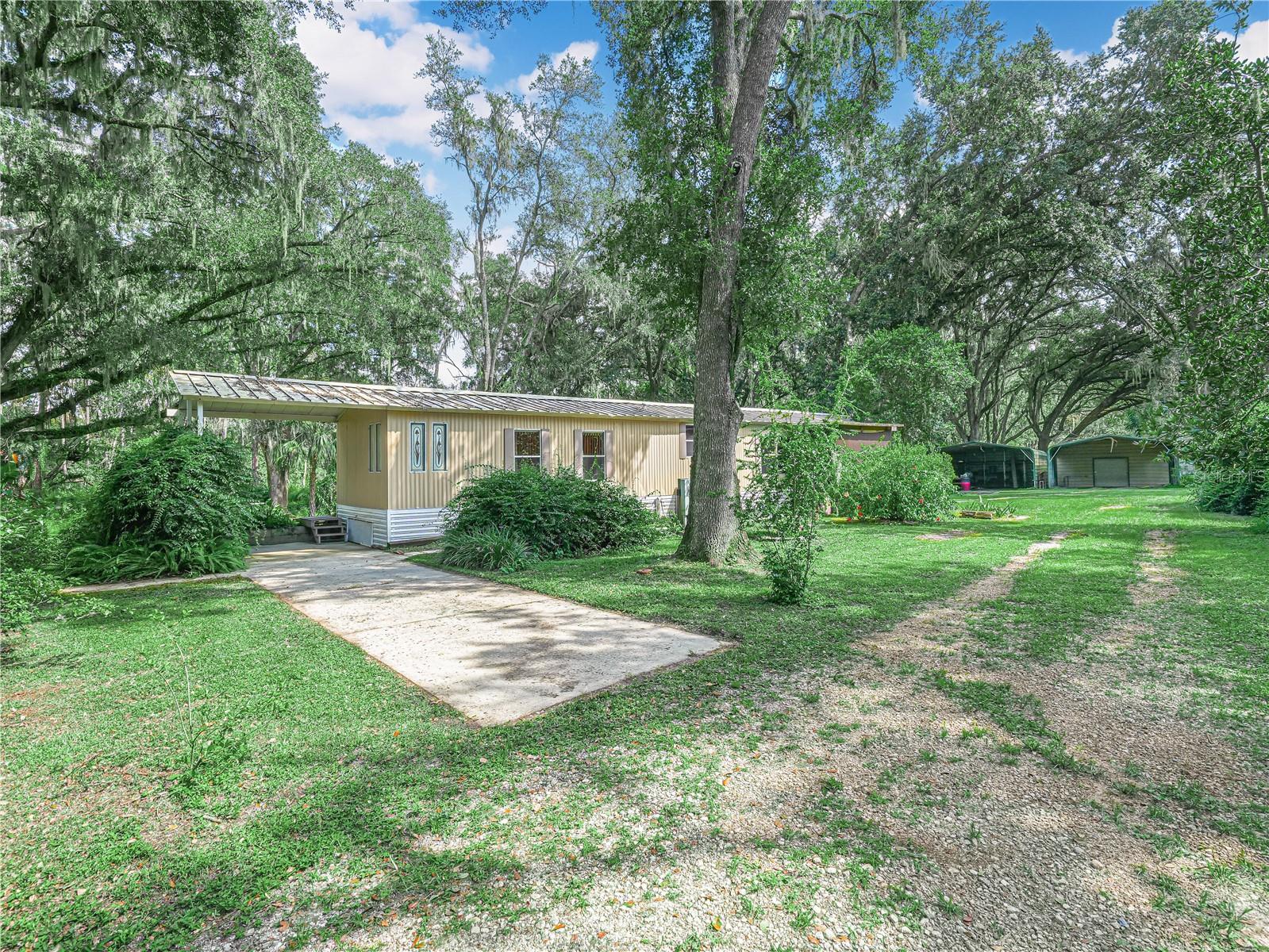 Two for One Opportunity – 3.62 Acres of Tranquility!
Discover the perfect blend of space, comfort, and natural beauty with this rare opportunity to own two parcels sold together as one expansive 3.62-acre property. Nestled in a serene, park-like setting, this property features a charming 2-bedroom, 2-bathroom mobile home with a spacious screened porch that overlooks the lush backyard—ideal for relaxing or entertaining.
Inside, the open-concept family room flows seamlessly into the dining area and kitchen, which comes fully equipped with all appliances. The laundry room includes a washer and dryer, making everyday living convenient and efficient.
The main bedroom boasts a walk-in closet and a private en-suite bathroom with a walk-in shower, while the second bedroom offers its own bathroom and a private entry—perfect for guests or multi-generational living.
Outside, you'll find two carports that provide ample space for parking, storage, or even a workshop. Whether you're looking for a peaceful retreat or a property with potential, this unique offering delivers both. Call now for your private showing.
