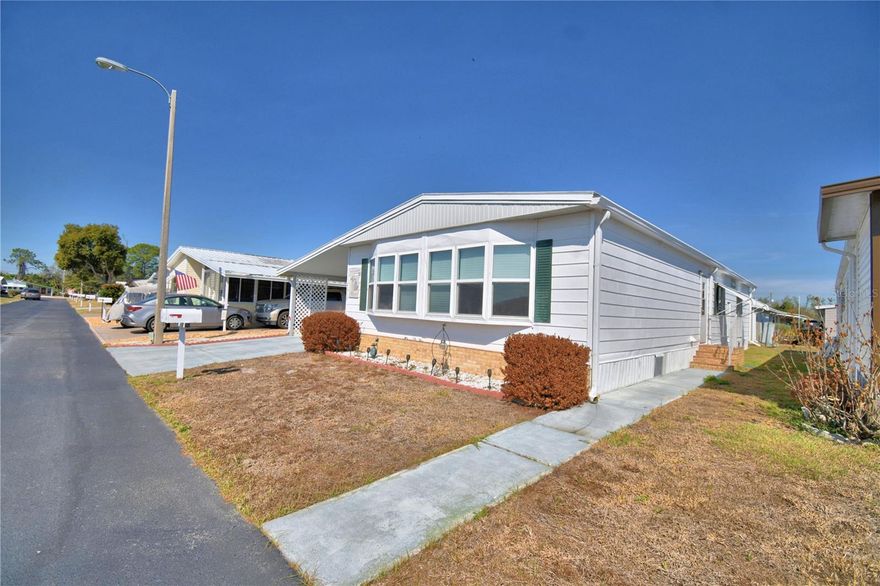 Open and spacious living area is the best way to describe this home.  The home features two living areas plus the lanai for additional space.  The primary bedroom is large offering two built in closets and a spacious bathroom.  The guest bedroom has the bath attached, perfect for visiting guests.  The kitchen has an updated island perfect for entertaining. The laundry is located inside the home. Move right into this home, perfect for full time living and spacious for entertaining all the visitors you may have.  Oakwood Estates is a 55+ communities with lots of amenities including two clubhouses, two pools, miniature golf, shuffleboard, tennis courts, and much more.  There are activities every day.  You can join in or just sit back and enjoy the peaceful community.
