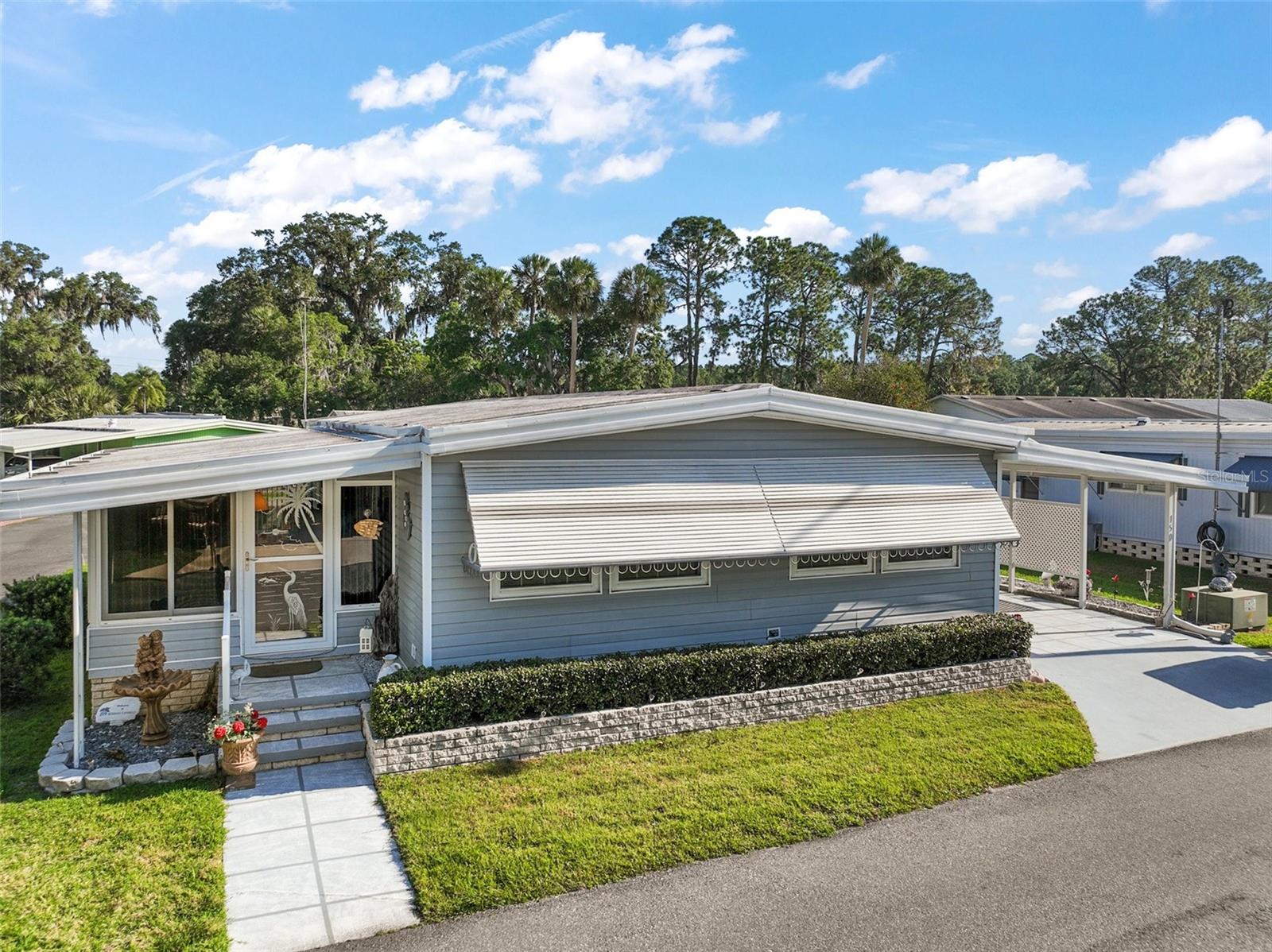 Renovated Double Wide in 55+ Country Club Manor – Includes Co-op Share! Located in the established and welcoming 55+ community of Country Club Manor in Eustis, this beautifully cared-for 2-bedroom, 2-bath double wide offers comfort, style, and affordable co-op living. With a co-op share included, you'll enjoy the benefits of ownership in one of the area's most desirable active adult communities. Since 2018, this home has seen major updates including a new roof-over, updated A/C system and ductwork, all new doors (interior and exterior, with one exception), and new windows throughout—with the exception of the living room. The interior features updated flooring throughout, tasteful finishes, and a layout designed for everyday comfort and entertaining. Inside you’ll find a formal dining area, a bright and open living room, and a fully enclosed Florida room that’s currently being used as a family room. The primary suite offers three closets and a private bath with a walk-in shower. The second bathroom features a convenient step-in shower—no tubs to worry about! All appliances convey, including the refrigerator, stove, dishwasher, washer, and dryer. Window blinds and drapes are also included. The carport features a custom hand-painted floor and leads to a spacious storage shed with laundry hookup. The low monthly fee of $231 covers water, sewer, trash, access to Lake Trout, the community pool, clubhouse, and more. Enjoy a peaceful, pet-free setting (service animals only), with shopping, pharmacies, and dining just around the corner—including Publix, Winn-Dixie, Walgreens, and CVS. This is the perfect opportunity for affordable, low-maintenance Florida living—schedule your tour today before it’s gone! All information is believed to be accurate but must be independently verified by buyer. Room sizes are approximate.
