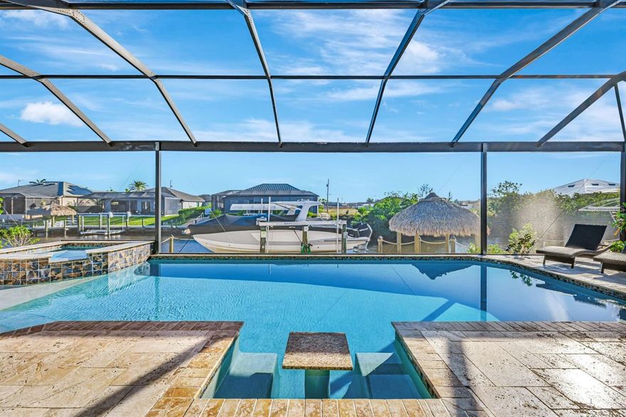 2 Owners Suites, Gulf Access, w/Pool, Composite Dock & 16k Boat Lift! Elegant & Modern, Durable & Efficient - Built to last in 2018 using ICF(Insulated Concrete Form) Construction w/STEEL REINFORCED POURED CONCRETE WALLS that reduces noise, are energy efficient, mold &mildew resistant, & most importantly ensures to protect against fires & hurricanes. 4-BR, PLUS den, ICF-built home offers over 3,100 sqft of living space & blends timeless travertine stone, neutral colors & nautical touches throughout. From the moment you pull up you can see this is not like the others. It starts w/the HUGE paver driveway that can accommodate 6+ cars, 3 oversized custom hurricane rated garage doors, stylish flat tile roof & paver walkway that leads to the elegant double door entry. Step inside to a grand foyer w/double-trayed ceiling adorned w/crown molding, decorative niches & tile inlay all creating an immediate sense of luxury. Travertine flooring flows from the front door through the entire home, all the way to the dock area & beyond. Great room boasts 12-foot coffered ceilings w/backlighting, complemented by 90-degree pocket sliding doors that seamlessly integrate indoor & outdoor living spaces. Formal dining area features tray ceilings w/recessed lighting & crown molding. Gourmet kitchen showcases Samsung Smart Connect appliance package, wall oven, stovetop, custom cabinets w/spice rack, dove-tail soft-close drawers, vent hood, tile backsplash and prep island w/ample counter space. Laundry room offers direct access to the owner's suite, featuring granite countertops for folding, upper & lower cabinets, & LG stacked washer & dryer. The spacious primary bedroom offers private lanai access, water views, & tray ceilings w/recessed lighting & crown molding. The ensuite bathroom is a spa-like retreat w/floor-to-ceiling travertine, soaking tub, walk-through shower w/multiple shower heads, & transom windows allowing for natural light. Home offers a second owner's suite w/private lanai access, an en-suite bathroom/pool bath & walk-in closet for added convenience. 3-cargarage is a standout feature, offering 12-foot ceilings (car lift friendly) & tiled floors, providing functionality & aesthetic for the perfect handyman haven. Step outside to your personal paradise. The lanai boasts unobstructed water views through picture window screens, heated custom pool w/sun shelf, lounging bench & cascading spa. Boaters will delight in the newer built low maintenance composite dock featuring tiki hut w/power & lighting &16,000 lb boat lift. Additional features include roll-down shutters, French drains, low maintenance zero scaping, & an outdoor shower on the lanai. This home is a true gem, offering an unmatched combination of elegance, functionality, durability & waterfront living. Assessments paid & furnishings are negotiable making this the perfect combination for YOUR luxury getaway! Don't miss the opportunityto make this stunning property your own!