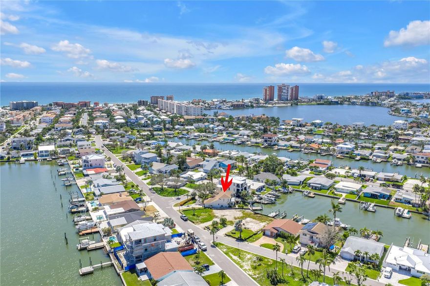 One or more photo(s) has been virtually staged. This home is also available for lease! Welcome to your elegant coastal retreat — a beautifully updated 4-bedroom, 4-bathroom waterfront home on a coveted corner lot, just a short stroll or bike ride to the sandy shores of Redington Beach.

From the moment you arrive, the circular driveway and manicured landscaping set the tone for this luxury residence. Inside, you’ll find high-end finishes throughout, including brand-new marble countertops, top-of-the-line appliances, and thoughtfully designed living spaces that showcase spanning water views.

The main level offers a bright living room, formal dining room, and a versatile sitting area off the gourmet kitchen with bar seating — ideal for casual meals or entertaining. Two bedrooms and two bathrooms (including one en-suite) complete the first floor. A large laundry room with sink and storage adds everyday convenience.

Upstairs, two additional en-suite bedrooms await. The expansive owner’s suite is a true retreat with dual walk-in closets, double vanities, a rain shower, a soaking tub overlooking the water, and private balcony access — also shared with the second upstairs suite — perfect for morning coffee or sunset views.

Outdoors, enjoy the best of waterfront living with your private dock for boating, a covered grill area for entertaining, and multiple spaces to relax and soak in the coastal lifestyle.

Staircase railing photos have been virtually rendered with a sleek, modern design. At the buyer’s request, the seller will install a similar updated railing prior to closing.

Every detail of this residence reflects coastal luxury, move-in ready for its next owner.