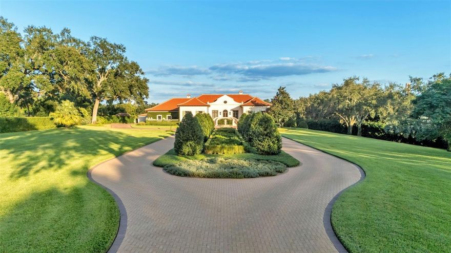 Set on 4.74 acres of meticulously landscaped grounds, this exceptional estate captures the essence of timeless elegance and modern sophistication. With sweeping views of open green spaces and the historic Bok Tower, this residence offers an unmatched combination of beauty, privacy, and grandeur.

Built in 1999, the main home spans an impressive 8,964 square feet of thoughtfully designed living space. Inside, soaring ceilings and expansive windows fill the home with natural light, creating a grand yet inviting atmosphere. Every detail has been crafted with refinement—from the well-appointed butler’s pantry to the chef’s kitchen, complete with top-of-the-line appliances, custom cabinetry, and abundant prep space ideal for entertaining or everyday living.

A private theatre, temperature-controlled wine cellar, and handsome library add to the home’s distinctive character, while ample storage throughout ensures both beauty and functionality. The seamless blend of classic architecture and modern luxury is evident in every finish and fixture.

Outdoors, the elegance continues. A resort-style pool and 1,656-square-foot pool house provide an additional haven for relaxation and gatherings, bringing the total living space to 10,620 square feet.  Surrounded by lush gardens and manicured lawns, every inch of the estate reflects a commitment to quality, craftsmanship, and design excellence.

This is more than a residence—it’s an extraordinary retreat, offering breathtaking views, refined living, and timeless appeal in one of Central Florida’s most scenic settings.