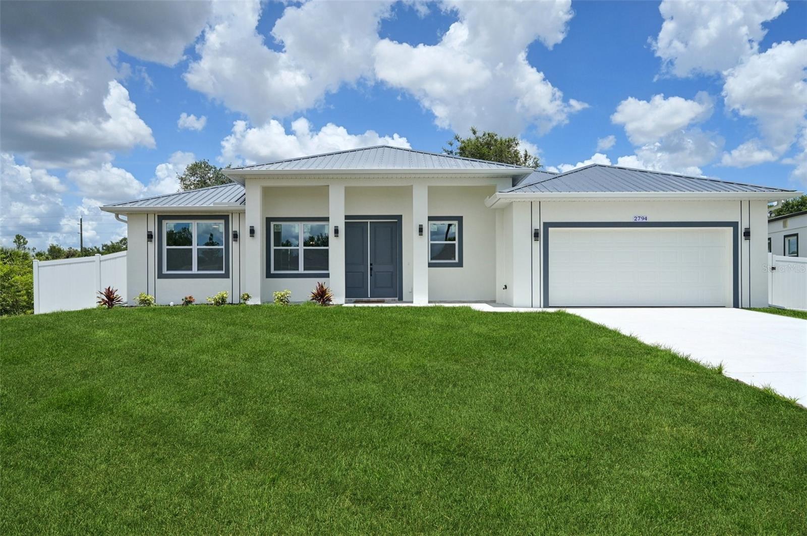 Move in Ready! CITY WATER - Step into quality and comfort with this beautifully constructed home featuring a durable metal roof, impact-rated windows, doors, and garage door, all designed for maximum storm protection and peace of mind. The home sits on an extended 12,000 sq ft lot with a privacy fence, offering ample outdoor space and privacy for relaxation or entertaining. Inside, you’ll find 10-foot ceilings and 8-foot double exterior doors, giving the home an open and luxurious feel. The kitchen boasts solid wood cabinets with soft-close hardware, granite countertops, LED lighting, ceramic tile and high-end finishes throughout. This home is Florida Green Building Coalition certified, providing enhanced energy efficiency and significantly lower insurance costs. Located in a NO FLOOD zone, it's the perfect combination of safety, efficiency, and style. The property also includes a builder’s warranty—a fantastic opportunity to own your dream home. Available now!