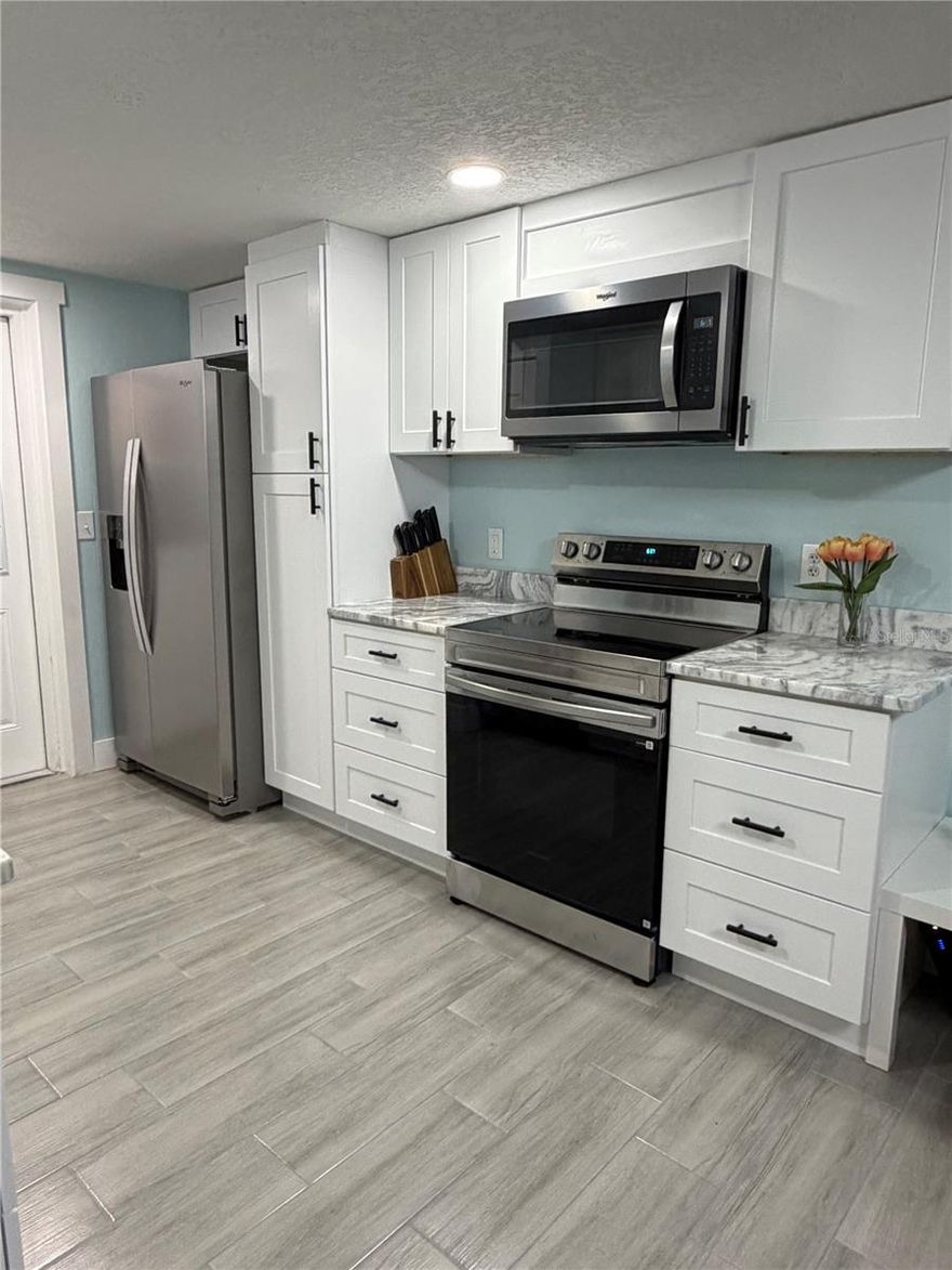 One block from the Beach!!! This fully remodeled duplex is so inviting. This property is ready for you to enjoy. You will love the stunning kitchen featuring new cabinets, granite countertops, and brand-new stainless steel appliances, along with beautiful plank-style wood tile flooring throughout. The primary bedroom is comfortably furnished with a queen bed, two nightstands, and a TV, creating a relaxing and inviting space. The second bedroom features a full bed, two nightstands, and a TV, making it perfect for guests or family. Step into the stunning bathroom featuring a custom tile shower with a luxurious waterfall shower head, creating a spa-like retreat. Enjoy relaxing and unwinding on your screened-in lanai, the perfect place to sit back and enjoy the coastal breeze. Or walk around the corner of the street for the stunning sunset.