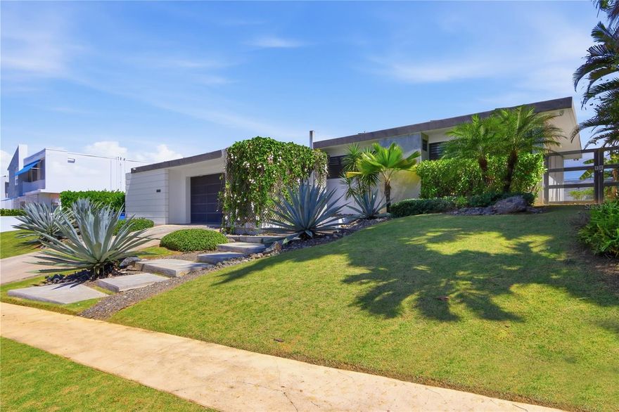 Located in the gated community of San Francisco in San Juan, this one-level residence offers the layout and scale today’s buyers are seeking. Set on a flat 1,200 square meter lot, the property provides both immediate comfort and long-term potential.
The interior features 4 bedrooms and 2 bathrooms, complemented by high ceilings and generous natural light throughout. The kitchen is spacious and bright, designed as the central gathering space of the home, with seamless connection to the patio and outdoor areas.
A dedicated wine cellar with capacity for approximately 300 bottles adds a distinctive touch for collectors and entertainers alike. The property also includes solar panels for energy efficiency and a flexible bonus room currently used as a gym, with independent access from the lateral patio—ideal for a studio, office, or guest suite. 
The expansive lot allows room for future expansion and outdoor enhancements while maintaining privacy and functionality. Solid construction, well-proportioned spaces, and a desirable floor plan create a residence that supports both everyday living and future customization.
San Francisco is one of San Juan’s most in-demand gated neighborhoods, known for its location, accessibility, and established residential character. CRIM: $637 semester HOA: $238 monthly