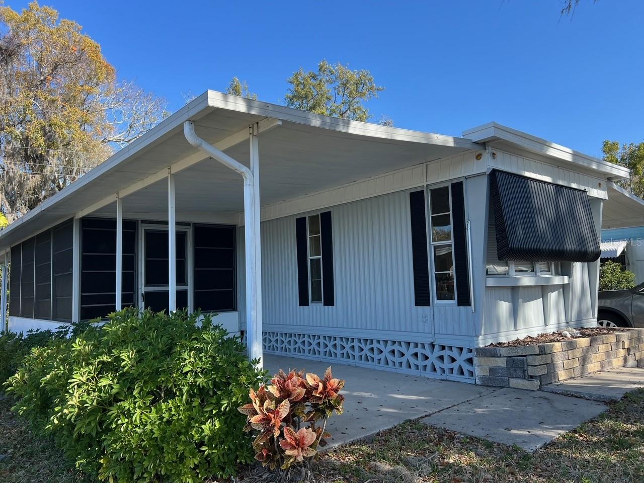 PRICE JUST REDUCED TO SELL IMMEDIATELY ** BEST VALUE IN PALMETTO UNDER 100K, YOU OWN A SHARE OF THE LAND VALUE IN THE COMMUNITY, AS THIS IS A CO-OP ** SELLER MOTIVATED ** QUIET AND SERENE LOCATION IN SOUGHT-AFTER LEISURE LAKES with LOW HOA FEES ** 2 BEDROOM, 2 BATH with an EXPANSIVE GREAT ROOM PLAN ** RECENTLY UPDATED WITH MODERN TOUCHES AND FRESH INTERIOR/EXTERIOR PAINT ** COMMUNITY POOL, GATED ENTRANCE AND FANTASTIC VIEWS AMONG THE SOARING TREES & GORGEOUS LAKE ** Look no further than the best value in Palmetto, listed under 100k with 2 bedrooms, 2 full baths while sitting in a gorgeous location inside Leisure Lakes. You will love the newer wood looking low maintenance flooring throughout the family area and huge primary suite. This home has been painted inside and out along with a fresh restore of the kitchen cabinets. Located just outside the family room is a screened patio area where you can enjoy cool Florida breezes and striking sunsets to the west (the patio faces west, carport faces east) Schedule your appointment to view today