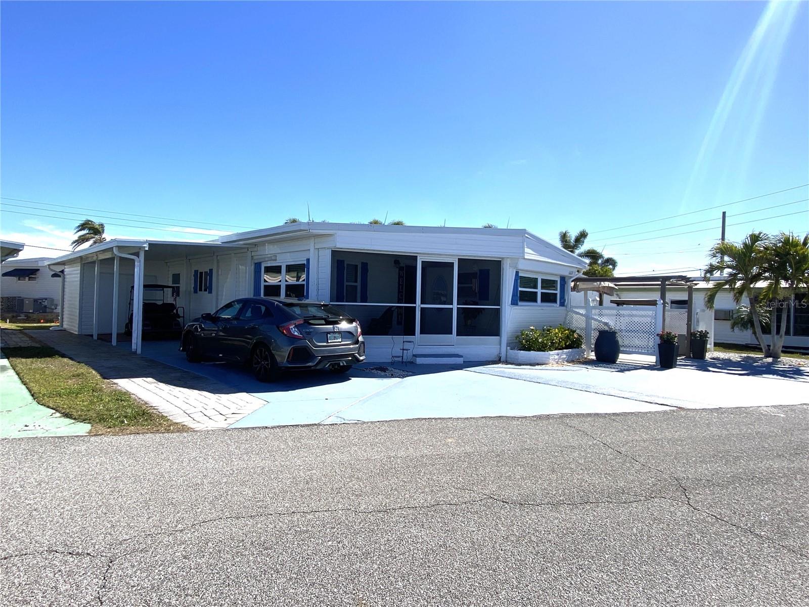 Spacious and updated, this 3-bedroom, 2-bath home sits on an oversized lot and a half in the sought-after Trailer Estates 55+ Marina Community. Designed for comfort, it features dual carports, a large workshop plus a storage shed, and an all-season room with A/C, plus a covered outdoor area and pergola perfect for enjoying Florida’s coastal lifestyle. Inside, the open floor plan blends modern updates with vintage charm, including an updated kitchen, All-Weather Roof, a 3-unit mini-split system, and two portable electric fireplaces. This home comes partially furnished with a kitchen dining set, second bedroom furniture, and a living room couch, and includes a golf cart.
Located in a Special Parks and Recreation District, there is no lot rent, CDD, or HOA fee, and the annual park tax covers cable, internet, trash pickup, fire and rescue services, and community amenities. Residents enjoy a marina with boat slips (as low as $600/year), a sandy beach area with a pavilion, pool, hot tub, fitness center, shuffleboard, bocce ball, and over 60 clubs and social events. Call today to see this rare find in one of Sarasota Bay’s most desirable 55+ communities!
