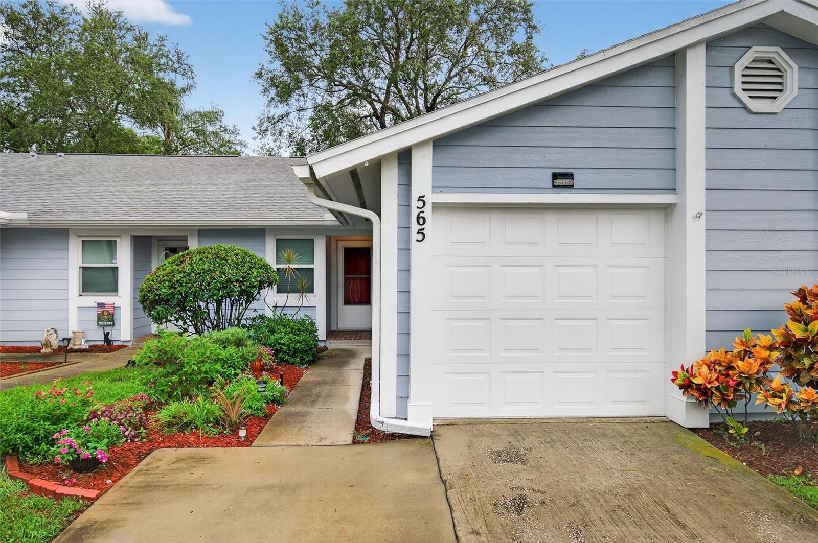 One or more photo(s) has been virtually staged. Welcome to this well-maintained 2-bedroom, 2-bathroom villa in Tarpon Springs! Situated across the street from A.L. Anderson Park on beautiful Lake Tarpon, and not far from Honeymoon Island State Park, this cozy villa offers a rare blend of nature, privacy, and convenience.
Step inside to find a spacious open-concept layout featuring tile and wood-style flooring, vaulted ceilings, and the perfect amount of light. The timeless kitchen boasts crisp white cabinetry with Corian counters, a full appliance package, and a pass-through window to the dining area, making entertaining easy and efficient. The adjoining living and dining space is perfect for gatherings or relaxing evenings, with sliding glass doors that lead out to a screened-in patio, perfect for enjoying the beautifully maintained garden.
You'll also love the private garage, ideal for parking or extra storage, and appreciate the low monthly HOA fees that cover exterior maintenance. Whether you're downsizing, buying your first home, or looking for a seasonal retreat, this property is sure to check all the boxes!