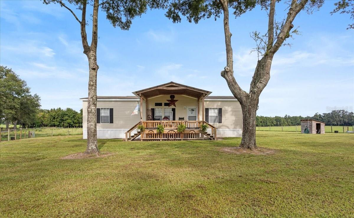 This private slice of paradise sits on 17 acres of individually fenced and gated pastureland, perfect for horse lovers or raising a few cattle in a tranquil setting. Located just moments away from Florida's stunning natural springs and state parks, and only a short drive from downtown High Springs, Alachua, or Newberry, this is ideal country home is 15 minutes from everything.
The move-in-ready, thoughtfully designed home features high ceilings and an open floor plan that make for a perfect blend of comfort and functionality. The chef's kitchen, with its open concept layout, is centered around a custom island that includes a built-in table area, accommodating family gatherings and entertaining friends with ease. The large adjacent living room and dining room are bathed in natural light, thanks to architectural combination transom windows that frame picturesque views of the surrounding landscape, allowing the beauty of the outdoors to flow seamlessly inside.
Retreat to the generous master suite, a haven of relaxation that also boasts a considerable walk-in closet. The spacious master bathroom has both a walk-in shower and a soaking tub, perfect for unwinding after a long day. The home also features two spacious guest bedrooms, complemented by a comfortable guest bathroom with modern fixtures and a relaxing atmosphere.
Outside, the expansive property includes 17 acres of green pastureland that is fully fenced and sectioned into gated paddocks, with a large pole barn, providing ample storage. A covered wooden deck out front invites you to enjoy peaceful afternoons in the sun, while the spacious covered back patio offers sunset views of the pasture. The protected carport out back ensures you have a safe place to keep all your outdoor toys.
Don’t miss this incredible opportunity to immerse yourself in the peace and tranquility of country living!