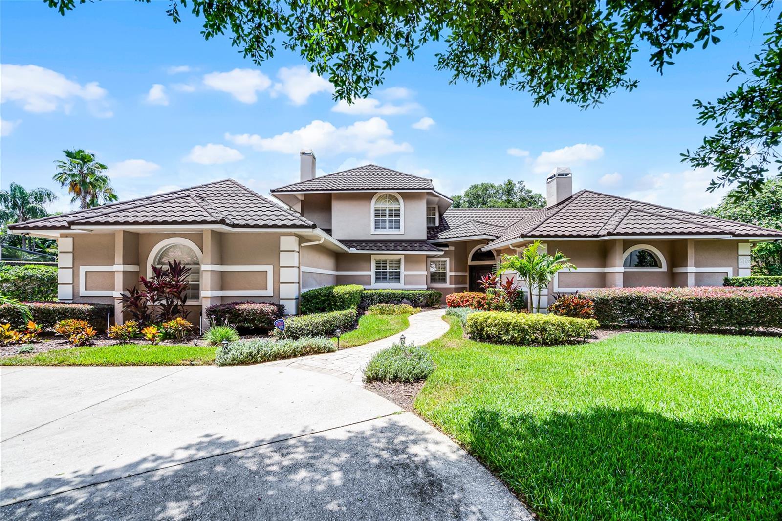 A SPECTACULAR South Bay home! Conveniently located near the Sand Lake Road and Apopka-Vineland Road intersection, and sitting on an oversized pie-shaped cul-de-sac lot, is one of the nicest, custom homes in the area. A 2-story, classic Florida custom home that has nearly everything a family would want. High ceilings, crown moldings, engineered wood floors throughout, natural light, soothing modern decor and quality materials and craftsmanship. The Primary bedroom and bath couldn’t be better - great size, Plantation shutters, 2-way fireplace, built-ins, huge dual vanity with granite counters, an oversized Garden tub & dual-head walk-in shower, spacious organized walk-in closet with drawers & wood floors. HUGE Family Room-Kitchen combo features an elevated breakfast bar island, Granite tops, Travertine backsplash, 42’ custom cabinets, stainless appliances, walk-in pantry, wet bar with ice maker & wine cooler, an abundance of drawers, fireplace with stacked stone & mantle. Also on the main level is the 5th bedroom with a deep closet, or as a home Office. An oversized laundry room leads to a home gym with laminate floors, mirrored wall and circulated air (this was a 3rd car bay, and is easily converted back!) The second floor is comprised of 3 bedrooms, Jack n Jill full bath, and an En Suite, all beautifully appointed, great for guests or kids. An ENORMOUS 52’ covered Lanai features classic Mexican tile, wood ceilings, a full walk-up Entertainment bar & multiple sets of French doors. Inviting screened pool & spa(recently resurfaced), surrounded with a brick paver deck. LARGE, fully fenced yard, custom shed & Greenbelt views. Rounding out this amazing home is a NEW Stone-coated Metal roof with gutters, large side garage, circular driveway and beautiful landscaping with 2 mature oaks located away from the home, but with nice front shade. South Bay community features include a playground, tennis/pickleball, jogging trails and a fishing dock. Arnold Palmer’s Bay Hill Club & Lodge is a short golf cart ride. Dr. Phillips restaurants, shopping and 3 Publix are within minutes. A really delightful, comprehensive property.