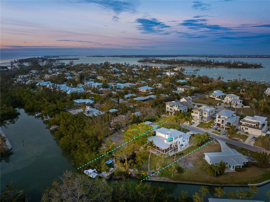 Nestled on an oversized waterfront homesite of nearly 17,000 sq. ft., this quality-built, elevated coastal oasis is "natural Florida" at its best. As you approach the architecturally designed home, a tree-lined drive and lush landscaping set the stage for the island lifestyle that awaits. The private setting, the deep-covered terraces, and generous windows beautifully capture the essence of a welcoming hideaway. Awash in natural light cascading from soaring ceilings, the open flowing plan, and the seamless integration of the indoor spaces with 1200 sq. ft. of decks, provides a harmonious sanctuary for relaxation or social gatherings. The living room and dining room flow to an inviting deck that wraps the home's west and south elevations, and offers picturesque views and access to the large secluded backyard, the Brazilian Ipe boat dock with a 10,000 lb. lift, and the natural shoreline below. At the heart of the home, the bright, open kitchen prioritizes both function and aesthetics. Generous cabinetry and workspace, a coffee corner, a dining bar, Caesarstone countertops and backsplashes, a single-bowl stainless sink, gas cooking, and direct access to the kitchen terrace for your grill and pizza oven make it a chef’s delight. The ultimate owners' retreat encompasses the entire top level of the home and is accented by a cozy terrace with panoramic bayou and peek-a-boo gulf views. A window-lined office area and two walk-in wardrobes, a spa bath with a deep Victoria & Albert soaking tub, an oversized glass-enclosed shower with Graff fixtures, a double floating vanity with lighted Robern cabinets, and a makeup area with a Kohler triple-lighted mirror complete the space. Additionally, two guest rooms and a full bath are conveniently located on the main level, along with a powder bath, a comfortable den/media room with triple bay windows, and laundry. On the home’s entry level, you’ll find a 1200-bottle wine cellar to accommodate a prized collection and a 600 sq. ft. Bonus Room with a half bath - the perfect place to work from home, work out, or pursue hobbies. The 900 sq. ft garage easily accommodates two or three vehicles, a golf cart, plenty of beach gear, and storage. Solid heart-walnut floors, deep base mouldings, and a wood-burning fireplace bring warmth to this artistic custom home, while the standing-seam roof brings style and security. Ideally located in the vibrant Village of Longboat Key, a neighborhood renowned for its stunning natural beauty, direct access to the pristine beach and sparkling bay, walking and biking paths, restaurants, shops, and neighborhood gatherings,  there are endless recreational possibilities. Launch your kayak or boat, drop a fishing line, or watch the manatees and dolphins at play - all from the convenience of your large backyard, and all just minutes from the Gulf of Mexico. Jump on your bike or golf cart or walk to a morning Pilates or weight workout, enjoy a leisurely coffee at the local cafe, take in a dramatic sunset on one of the area's prized beaches, or meet friends for dinner at one of the island's popular restaurants. For the first time, this solidly constructed, meticulously maintained home, with its harmonious blend of sophistication and comfort, is awaiting the next fortunate owners. Substantial price reductions make this one of the best values on the island. Realtor Owner.