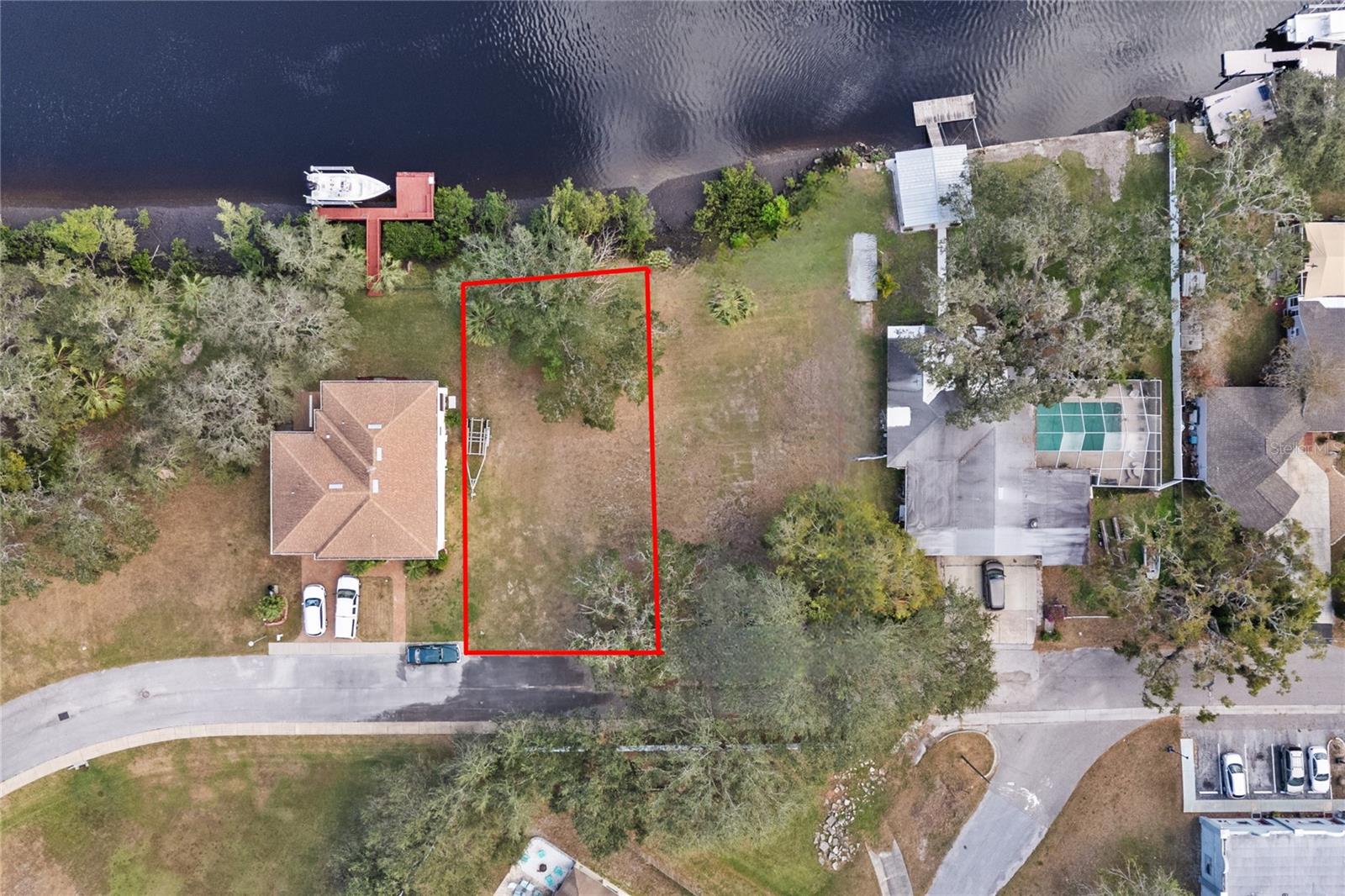 HIGH AND DRY on the PITHLACHASCOTEE (COTEE) River with easy deep-water access to the Gulf of Mexico. The waterfront lot elevation offers a rare opportunity to build on-grade, no stilt house. This will save tens of thousands in construction costs. A private gated community offers a peaceful, quiet and secure riverfront setting. Just add your own dock and lift. Deep water for large boats. Lot is cleared and ready for building. Located near downtown New Port Richey, just south of Main Street. New Port Richey is a golf cart friendly community offering numerous restaurants, breweries, Live theater, shopping, and entertainment. Music and festivals are held regularly at Sims Park. Local activities include Farmers Markets, craft shows and much more. Great kayaking up stream to Nature’s Own Parks. A short trip downstream towards the Gulf of Mexico takes you to several waterfront restaurants on the river. Whiskey River, Catches, Whiskey Joes, Hooters, to mention a few.. Bring your boat and build your waterfront dream house today. Tampa International Airport is a short 45 minutes away. Lot next door available for sale as well. MLS #W7870837