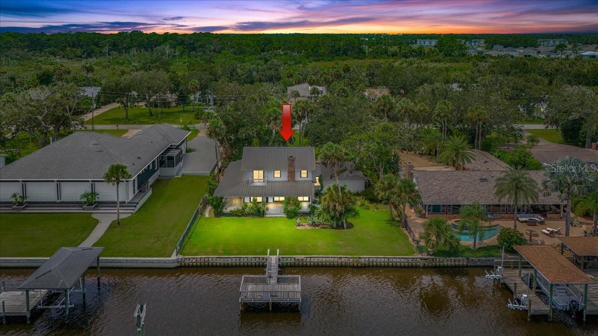 Welcome to one of Flagler Beach's true gems, perfectly positioned on prestigious Lambert Avenue with beautiful direct Intracoastal frontage. This inviting Cracker-style home combines timeless charm with modern comfort, offering the perfect blend of indoor-outdoor living. A three-sided, 12-foot wraparound porch welcomes you into this home, ideal for morning coffee, entertaining, or simply taking in the breathtaking water views. Inside, you'll immediately notice the craftsmanship: warm wood accents throughout, open ceiling beams, and a stunning brick fireplace designed for wood burning with the convenience of a propane starter. The spacious kitchen is a true centerpiece featuring wood cabinetry, a center island, breakfast bar, and Saltillo tile flooring that flows seamlessly across the first floor. A beautifully crafted open-tread staircase leads upstairs, while numerous wood patio doors showcase panoramic views of the Intracoastal Waterway and the daily ''boat parade.'' Upstairs, the private primary suite offers a cozy sitting area, a balcony overlooking the water, and plenty of natural light. Practical features include a large two-car garage with storage and laundry, hurricane shutters. The property's mature landscaping provides both beauty and low-maintenance living. Step outside and enjoy fishing or boating out of your private dock. Flagler Beach at its finest is just a short walk to the ICW pedestrian bridge leading you straight to the beach, with Wadsworth Park, local shopping, and dining just around the corner. For commuters, I-95 is only 4 miles away, giving you convenient access to both Daytona Beach and St. Augustine. This unique waterfront property truly embodies the Flagler Beach lifestyle warm, welcoming, and perfectly located. Don't miss the opportunity to call this special home yours.