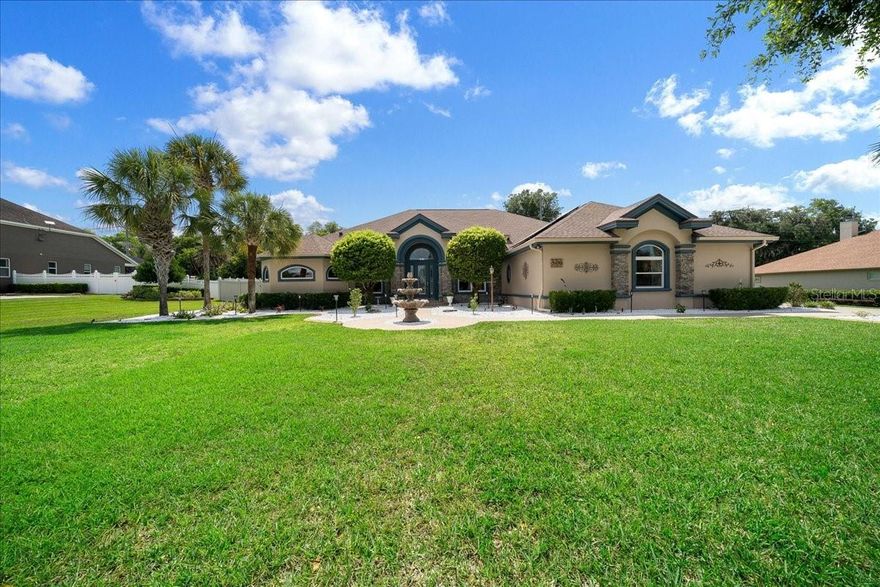 Experience luxury living at its finest in this extraordinary estate located in one of the area’s most highly sought-after gated communities, perfectly positioned near premier shopping, top-rated hospitals, dining, and everyday conveniences. Situated on a private 1.08-acre homesite with no rear neighbors, this breathtaking 4-bedroom, 4-bath residence with a dedicated office offers over 4,053 square feet of impeccably upgraded living space designed for both grand entertaining and refined everyday living. From the moment you arrive, the elegant front fountain, lush landscaping, privacy fencing, and impressive curb appeal create an unforgettable first impression.
Step through the doors into a stunning interior showcasing soaring 12’ to 16’ ceilings, magnificent travertine flooring, designer lighting, and expansive living spaces filled with natural light. Every inch of this home has been thoughtfully enhanced with luxurious finishes and modern upgrades. The gourmet kitchen is a true showpiece featuring beautifully updated cabinetry, gorgeous quartz countertops throughout, upgraded sinks, and premium appliances including a sleek induction cooktop and a high-end double drawer Café Series dishwasher. The kitchen flows effortlessly into the main living and entertaining areas, while a stylish wet bar further elevates the home’s entertainment appeal, creating the perfect setting for hosting guests in elegance and comfort. A private office space provides the ideal setting for working from home, managing a business, or creating a quiet retreat. The resort-style outdoor living space is nothing short of spectacular. Relax and entertain year-round in the oversized screened lanai complete with a fully equipped outdoor kitchen overlooking the stunning oversized pool. The pool area has been extensively upgraded with brand-new marcite/gunite, a new skimmer, gas pool heater, and solar heating system, delivering the ultimate private backyard oasis. Additional exterior enhancements include patio blinds, a newer Hunter irrigation system, and a concrete slab with double gate access ideal for boat parking or additional recreational storage. This exceptional home is loaded with premium upgrades including newer windows, updated air conditioning, a 2024 roof, solar panels, EV car charger, remote-controlled Magic attic stairs, redesigned custom closets throughout, and a spacious 3-car garage. For added peace of mind, the property also includes a whole-house Generac generator, providing comfort and reliability year-round. Every detail was carefully selected to blend luxury, sophistication, comfort, and energy efficiency. Offering privacy, elegance, and an incredible location within a prestigious gated community, this one-of-a-kind estate truly has it all. Homes with this level of quality, space, and upgrades rarely become available — schedule your private showing today before this remarkable property is gone!