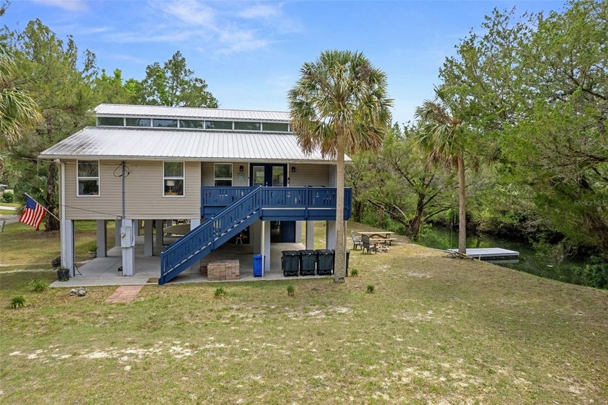 Tucked away at the end of a quiet private road, this elevated waterfront retreat captures the relaxed charm of Old Florida living while offering the flexibility today’s buyers crave. Situated on TWO CANAL-FRONT LOTS with access to the stunning Homosassa River via the Halls River, this beautifully remodeled 3-bedroom, 2-bath stilt home blends coastal comfort, investment potential, and room to grow. From the moment you arrive, the inviting Florida vacation vibe sets the tone with abundant covered parking beneath the home for vehicles, boats, trailers, golf carts, and all your waterfront toys, plus an enclosed storage area for added convenience. Climb the composite board staircase with deep blue wood railing to the inviting front porcha and double door entry. Step inside and natural light pours through dramatic transom windows stretching across both peaks of the home, creating an airy, sunlit atmosphere throughout the living spaces. A large picture window frames peaceful backyard nature views, bringing the outdoors in. The thoughtfully designed split-bedroom floor plan offers ideal owner privacy, while the spacious primary suite features a walk-in closet, jetted soaking tub, and separate shower for a spa-like retreat. The upper loft adds incredible versatility as a bonus room, game area, office, or additional sleeping space for larger gatherings and vacation guests. Outside, enjoy your floating dock with easy boating access to the river, springs, restaurants, and Gulf waters beyond. The additional unimproved corner lot offers rare flexibility—preserve it for added privacy, expand outdoor entertaining, or develop for future possibilities. With no deed restrictions, this property also presents an exceptional opportunity for personal enjoyment, seasonal escapes, or short-term rental income potential. Quiet, private, and surrounded by nature, this is the kind of waterfront property people come to Florida hoping to find.