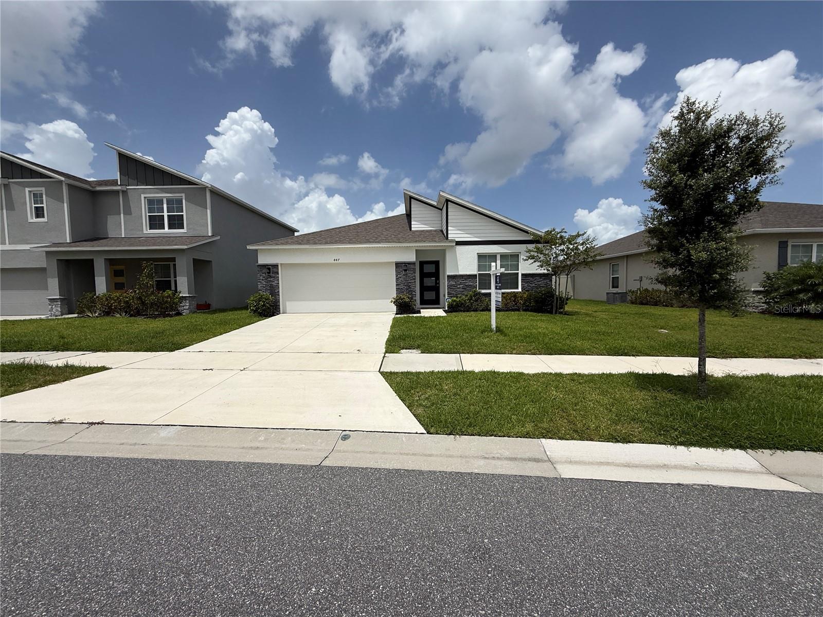 Wake up to peaceful water views and sleek modern design in this beautifully appointed 4-bedroom, 2-bath home in the sought-after Summerly community of Saint Cloud. With striking contemporary curb appeal—highlighted by stacked stone accents—this home blends stylish finishes with everyday comfort. Inside, the smart 3-way split floor plan offers both space and flexibility. Two bedrooms and a full bath sit near the front of the home, while a third bedroom, laundry area, and garage entry are thoughtfully positioned off an open hallway. At the heart of the home, you’ll find an expansive, light-filled living area anchored by a stunning kitchen featuring quartz countertops, stainless steel appliances, shaker cabinetry, a timeless subway tile backsplash, and a large center island ideal for entertaining or casual meals. The dining area opens to an inviting lanai and large backyard, where you can take in beautiful water views—perfect for morning coffee, evening sunsets, or weekend gatherings. The private primary suite is a true retreat with elegant board and batten accents, peaceful backyard views, a spa-inspired bath with dual vanities, a walk-in shower, and a spacious walk-in closet. Design upgrades throughout include luxury vinyl plank flooring, a modern frosted glass front door, five-panel shaker-style interior doors, and stylish lighting and ceiling fans. Living in Summerly means access to a resort-style pool and cabana, playground, and scenic walking trails. Plus, you’re just minutes from Lake Nona, Medical City, major highways, and only 20 minutes from Orlando International Airport.