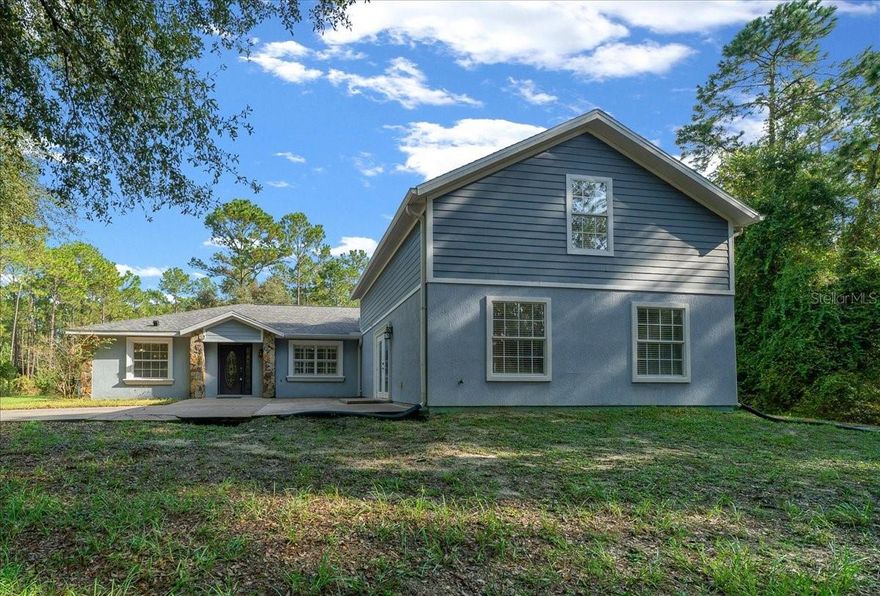 One or more photo(s) has been virtually staged. Buyers financing fell through and this beauty is back on the market! Sitting on 20 acres, this wooded property features a 4-bedroom, 4-bath home with a brand a new roof and brand new HVAC system, offering peace of mind for years to come. The original home was constructed by Triple Crown Homes, known for their quality craftsmanship and attention to detail, with a thoughtfully designed home addition to include a spacious 23x28 family room with a half bathroom, and a second upstairs primary suite with a full bathroom. A centrally located kitchen is the heart of the home with a breakfast area overlooking the wooded backyard, and a large dining area ideal for special gatherings. The main living area’s primary suite offers a spacious bathroom with dual sinks and a large walk-in shower, a walk-in closet, and private access to the screened lanai. Two additional bedrooms and another full bathroom complete this home’s floor plan. Walk the grounds and discover a covered pavilion with power that makes entertaining easy for cookouts and get-togethers. The detached 3-car garage (30x22) provides ample space for trucks, tools, or toys, while the RV carport offers additional storage for a travel trailer or boat. The expansive backyard serves as a blank canvas, ready for the custom pool retreat you’ve always imagined. Imagine creating your dream farm here, the way you want it. The land, zoned for agricultural use, is a balanced mix, ideal for trails, livestock, gardens, or horses. With 20 acres, you have options: keep it as one magnificent estate or explore subdividing for future homesites. With its size, updates, and acreage, this property is priced well below comparable estates in the area, making it not only a rare find in a great location but also a smart investment. All this, and you’re still less than an hour away from the World Equestrian Center with convenient access to both I-75 and I-95.