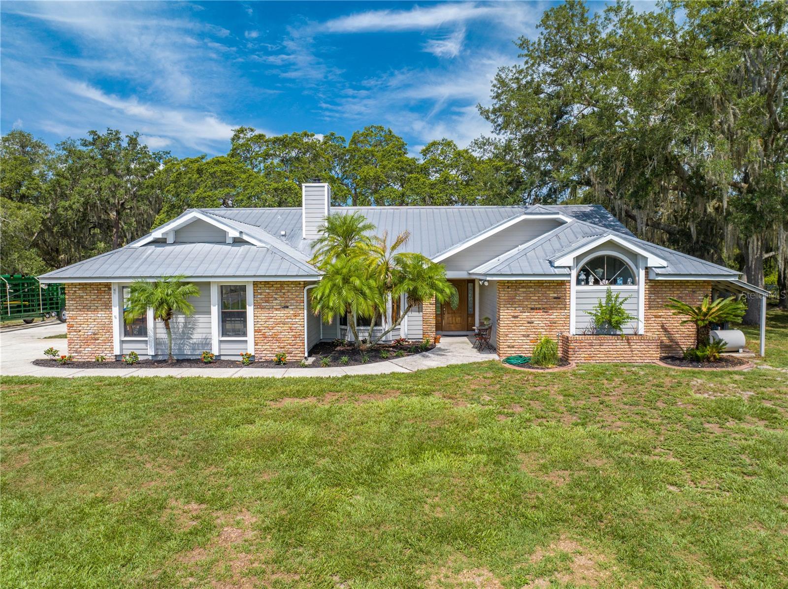 CHECK IT OUT!! Don't miss out on this extraordinary RARE one owner property! Welcome to your ultimate countryside retreat! This stunning property sprawls over 5 acres with grandfather oaks and includes not one, but two homes. The main residence boasts a spacious 4-bedroom, 2-bathroom split floor plan layout, a metal roof, and an A/C unit that was replaced in 2021, as well as a full replumb in 2021. Inside, you'll find an expansive living area and ample space for all your needs. upgraded kitchen features wood cabinets, granite countertops, an eating space, and Stainless Steel appliances. Additionally, it offers two living rooms and a large dining room area that is perfect for family gatherings. Step outside to enjoy an inviting large pool with Spa that was just resurfaced, along with a newly renovated pool deck and back porch with a new pool heater installed in 2023. The in-law suite offers an additional 2 bedrooms and 1 bathroom, making it ideal for extended family or guests. It features a large storage room and a separate laundry room that doubles as a mudroom, all leading to a cozy screened porch and a convenient carport. For horse enthusiasts, the property includes an impressive 8-stall horse barn equipped with power and water, and a concrete center aisle, making it a perfect setup for equestrian activities or an income producing Opportunity.. The barn also includes a tack room, hay storage, and a wash rack for horses, ensuring that your equine companions have everything they need. extraordinary property combines the peace of rural living with the convenience of modern amenities. Moreover, the estate features lush pastures and a riding arena, making it an equestrian's dream. The property's location offers easy access to nearby highways, golf courses, riding trails and Floridas Theme parks, enhancing the outdoor experience. This picturesque estate is the perfect haven for families and their four-legged friends. Don't miss the chance to make this exceptional property your new home! Call today for your private showing!