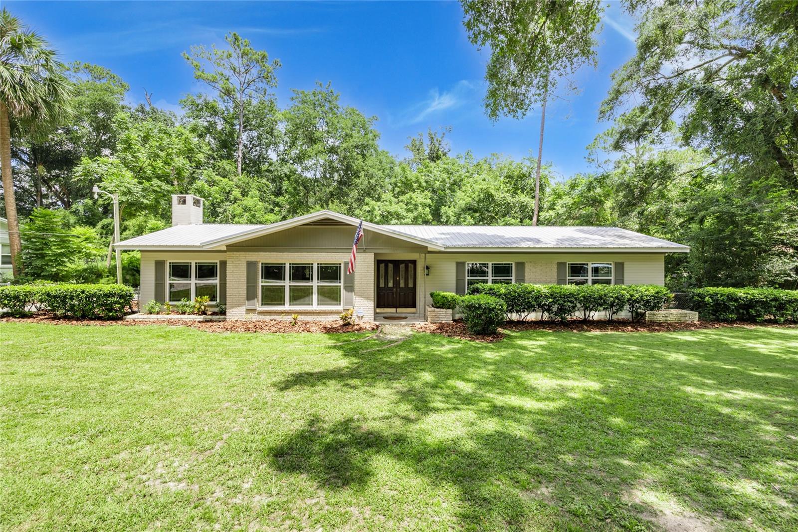 Fabulous Location located less than 3 miles to UF, Shands, Vet School, & VA, a classic mid century block home with metal roof and featuring gorgeous terrazzo floors with no carpeting. From the large & cozy fieldstone wood burning fireplace in the large living room to the updated double pane windows throughout the home, this spacious home is a pleasure to show. The rear screened patio overlooks the completely fenced large back yard with a nice built in storage space and laundry room.
