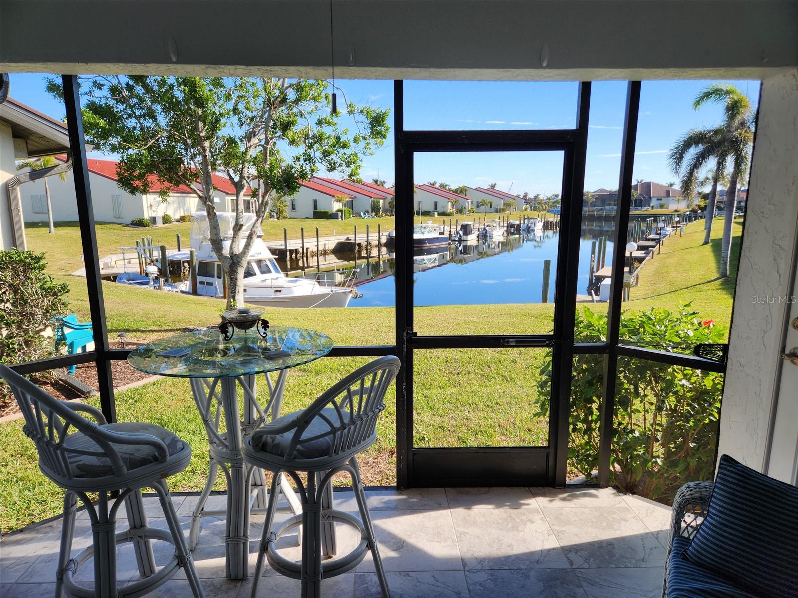 This is a beautiful and bright single-level end unit with vaulted ceilings throughout. It has a long canal view, with direct no-bridge access to Charlotte Harbor and a deeded dock just steps from the unit. The single car garage has easy access to extra storage in the attic. It is beautifully renovated with updated appliances, large tile throughout, and hurricane rated patio door and bedroom windows. Two spacious bedrooms and two bathrooms will accommodate all your visitors coming to experience beautiful Punta Gorda. As an end unit this home benefits from and additional large side window that fills the space with natural light. This home boasts two screened outdoor living areas. It has a front lanai to catch the sun and sunsets and a lanai facing the canal to watch the boats go by. The new metal roof, recently replaced by the Community Association guarantees the structural integrity of the home. For your peace of mind, there was no damage to the unit from recent hurricanes! The attached garage features pull-down stairs to a large storage space above. Monthly HOA includes water, sewer, trash, landscaping and pool maintenance. This unit is highly upgraded and shows beautifully. THIS ONE IS A GEM!! Don't wait to schedule a showing.