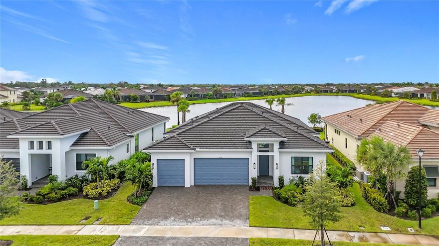 Welcome to 9132 Bernini Place which is set behind the exclusive gates of Sarasota’s coveted Artistry and situated on an expansive 10,409-square-foot unobstructed West facing lakefront lot for those stunning and ever changing sunsets. With 3 bedrooms, 3 baths, plus office/den space and a 2,118-square foot “Dali Model” floor plan this residence presents a perfect balance of luxury, comfort and privacy. The grand entrance leads inside to soaring ceilings with walls of glass slider doors that frame sweeping lakefront views and effortless indoor/outdoor living. Interior highlights include formal living and dining rooms, a stylish open chef’s kitchen primed for easy, elegant hosting and dedicated laundry area. The spectacular primary retreat is bathed in natural light with views of immaculately manicured grounds and features a spacious walk-in closet, oversized shower with dual vanities. The generous 3 car garage with epoxy flooring affords space for additional storage or golf cart. Artistry Sarasota is an amenity rich community that boasts a state-of-the-art fitness gym, pickle ball court, yoga studio and outdoor community swimming pool. Moments from downtown Sarasota’s luxury shops, vibrant arts and dining scene and the world famous beaches of Siesta Key and Lido Key. Completed in 2023, this estate presents an opportunity to own in a place shaped by both beauty and resilience.