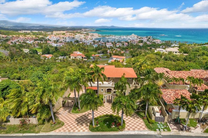 Fabulous estate available for sale at Palmas Del Mar resort. Beautifully designed home featuring an open concept floor plan. in the main level you'll find a gorgeous entrance foyer, living room, dining room, office with ensuite bathroom, Kitchen with walk-in pantry, informal dining area, powder room and wrap around balcony with view to the Caribbean Sea, El Yunque rainforest, Marina and the resort. The lower level includes a family room and games area, Koi pond, movie theater and 4 bedrooms, on this level you will also find the pool area with gazebo, grill, fire pit and full bathroom. Walk down the stairs from the pool area and you will find a one bedroom apartment complete with kitchen, full bathroom, living and dining area. Also in this level you'll find the garage a with plenty of storage and a fully equipped gym.