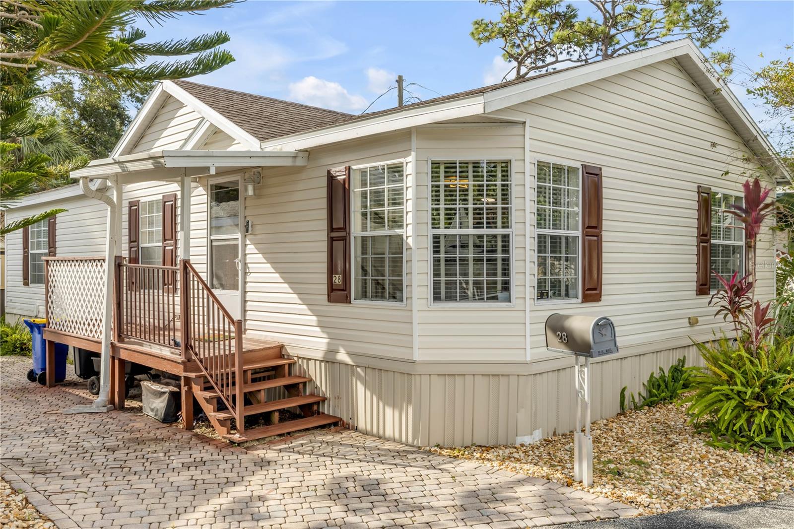 Discover coastal comfort in this well maintained 2-bedroom/2-bath home in a 55+ waterfront community. The home features a screened-in porch, shingle roof year 2021, A/C year 2022, and vinyl plank flooring in the kitchen, bathrooms and laundry room.  The updated kitchen has an over-the-range stainless microwave, sleek French door refrigerator, a stainless double sink with pull-down faucet sprayer and Reverse osmosis water filter. Custom plantation blinds throughout. Floodlight for back yard.   Generous storage shed was just added to the back yard with electric for your tools, hobbies or gear. Located just minutes to New Smyrna Beach. The Friendly Shores community boasts direct water access for fishing or boating, a community center with outdoor seating, a large fishing dock and kayak launch, and low HOA fees that cover water, sewer, trash and common-areas