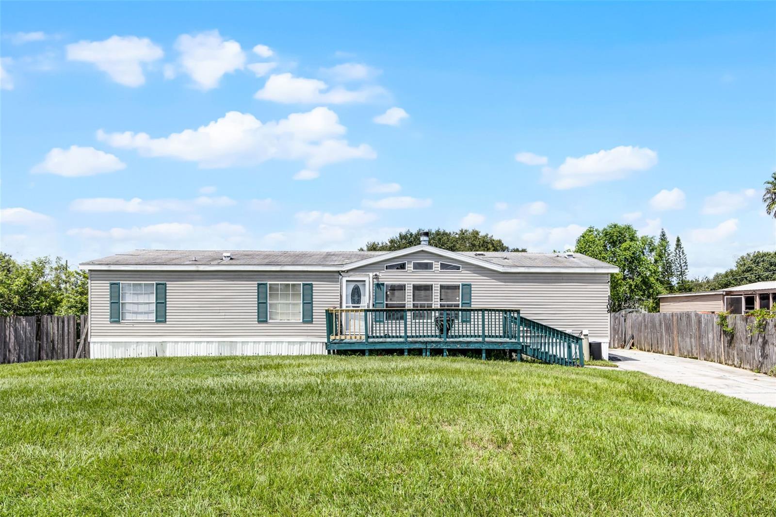 Spacious Double-Wide nests in Kissimmee Community – Over 10,000 Sq. Ft. Lot! Looking for room to spread out and enjoy the Florida lifestyle without restrictions. Welcome home! The home boasts with potential, this 3-bedroom, 2-bath double-wide mobile home offers a comfortable 1,620 sq. ft. of living space and sits on a massive 10,000+ sq. ft. lot — perfect for outdoor living, entertaining, or future upgrades. Step inside to a bright, open layout with plenty of room for family or guests. The kitchen flows into a large living and dining area, while the split-bedroom plan gives you the privacy you need. The primary suite features a full bath and walk-in closet, and the two additional bedrooms are just the right size for comfort, guests, or even a home office. Love the outdoors? This property is already plumbed and ready for your dream pool! Whether you’re looking to lounge, grill, or garden, this backyard has the space and potential to make it all happen. Located in Kissimmee 34741, just minutes from shopping, dining, schools, and major roadways — Perfect for investors, or anyone looking for freedom, space, and value. This one won’t last long — come see the possibilities!