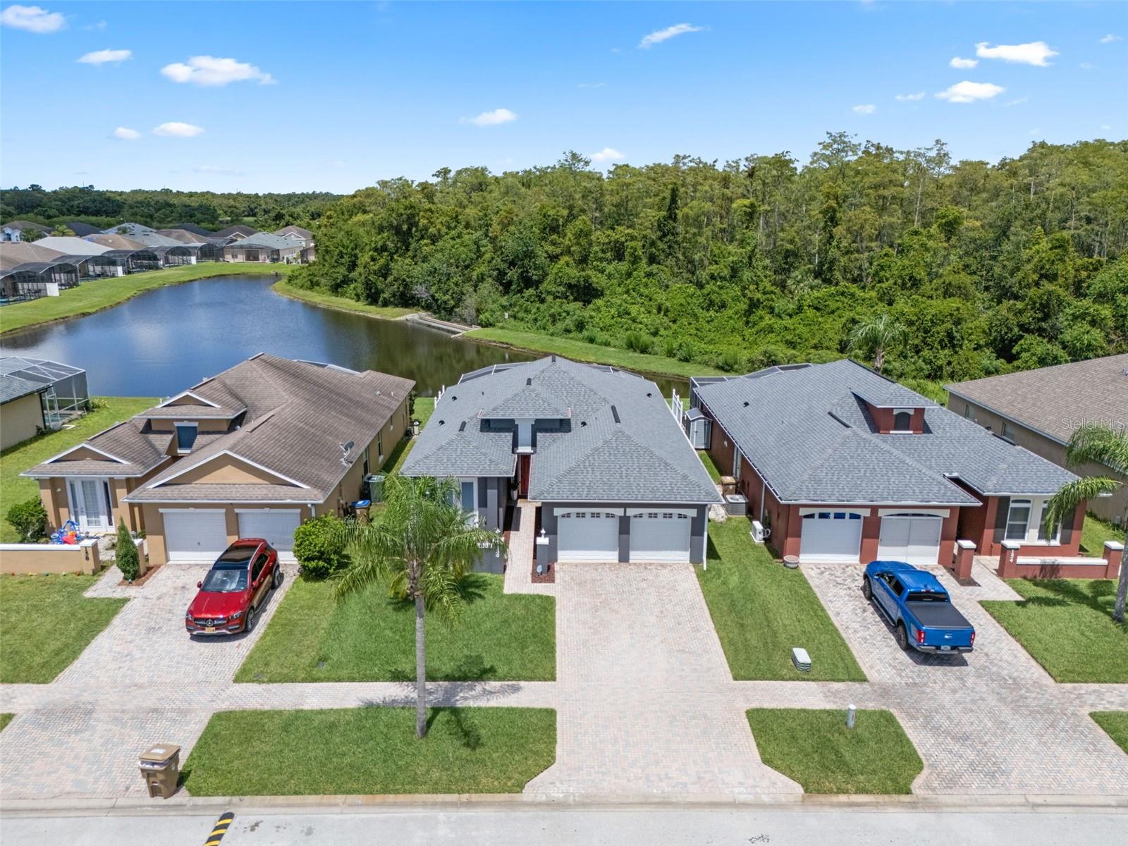 Wake up to water views, soak in the Florida sun by your private pool, and earn income while you're away—this fully furnished 4-bedroom, 3-bathroom waterfront home in a small, well-maintained gated Kissimmee community is the total package. Whether you're building a short-term rental portfolio or dreaming of a stylish second home that pays its way, this turnkey property delivers comfort, versatility, and location. Inside, the layout is bright and thoughtfully designed, with fully tiled floors that flow throughout the home. Two of the four bedrooms are spacious en suite bedrooms, each offering added privacy and comfort. The spacious en suite bedroom at the front of the home, includes French doors that open onto a charming private patio—perfect for morning coffee or quiet evenings. The back en suite bedroom offers peaceful views of the pool and pond from its window. Two additional guest bedrooms are positioned on the opposite side of the home with access to a third full bath, making the home ideal for accommodating multiple guests or visitors. The kitchen is both practical and stylish, offering two-tone cabinetry, updated counters, and a breakfast bar that overlooks the dining and living areas. The open-concept design ensures smooth flow from room to room, with the living area offering direct access to the screened patio and pool deck via elegant French doors. With water views framed by large windows, the main living space feels airy and connected to nature. Step outside to enjoy a screened pool with extended sun deck and wide views of the pond beyond. The backyard is a peaceful retreat, perfect for lounging or entertaining, and the home’s turnkey furnishings make it easy to settle in or start renting immediately. The front of the home features a cozy patio, a brick-paved driveway, and attractive curb appeal. The garage, like the rest of the home, has been well cared for, and the entire property reflects a pride of ownership that’s hard to miss. Zoned for short-term rentals and located just 2 minutes from Florida’s Turnpike, 20 minutes from the airport, 30 minutes from Disney, and just over an hour from the east coast beaches, this home offers excellent accessibility for travelers and vacationers alike. With its waterfront setting, flexible layout, and strong rental potential, this home offers the perfect blend of lifestyle and income opportunity.