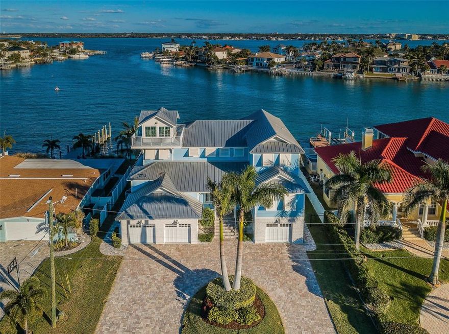 A masterful achievement of concept and design, this stunning custom built 4,000 square foot tri-level WATERFRONT residence showcases exquisite craftsmanship & cutting edge design. Seamlessly integrated indoor/outdoor spaces with an enclosed "lookout tower" which affords panoramic sunrises over the Clearwater Harbor Intracoastal as well as gorgeous sunsets over the Gulf of Mexico, 80' of waterfront, sailboat water, private dock with 24,000 lb lift, saltwater electric heated PebbleTec pool, walkway & waterfall feature, outdoor grill+big green egg & glass top high bar perfect for entertaining. Illuminated by natural light the great room with its v-groove volume ceiling, crown molding, wood look tile floors, gas fireplace, granite top cabinet storage, shiplap & mounted TV, ceiling fan & surround sound is open to the dining room & kitchen. The dining room room overlooks the intracoastal waterway, 3-pendant lights & remote shades. Culinary kitchen: stainless Viking appliances, granite top coastal blue canter island 6-burner gas cooktop, glass tile backsplash, triple glass slider opens to exterior balcony. Private glass wine closet, butler's pantry, walk-in pantry & powder room. Elevator. Master suite overlooks the Waterfront, crown molding, wood floors, fan. His/her walk-in closet, laundry closet stackable washer & dryer, granite top storage island. Sumptuous master bath 2-vessel sink vanity, walk-in shower, linen cabinets & water closet. 2nd bedroom has fan, wood floors, crown molding with bath en-suite. Upstairs bonus room is ideal for a private den & is adjacent to 3rd bedroom overlooking the Waterfront, bath en-suite. 4th bedroom wood floors, fan & wall closet. Guest bathroom 2-vessel sink vanity adjacent to the game room overlooking the Waterfront, beamed ceiling, built-in storage cabinet. The office (currently used as twin beds) overlooks the Waterfront. Interior laundry room, utility sink, front load Samsung washer/dryer, granite top, cabinet storage. Library peaceful retreat! 3-car garage which can accommodate 4 cars as the single bay is tandem - epoxy finished floors. Covered patio: Hisense TV, privacy shutters, V-groove ceiling. Professionally landscaped, paver circle driveway, Rinnai tankless gas water heaters. 1 walking block to the Belleair Beach private beach access!