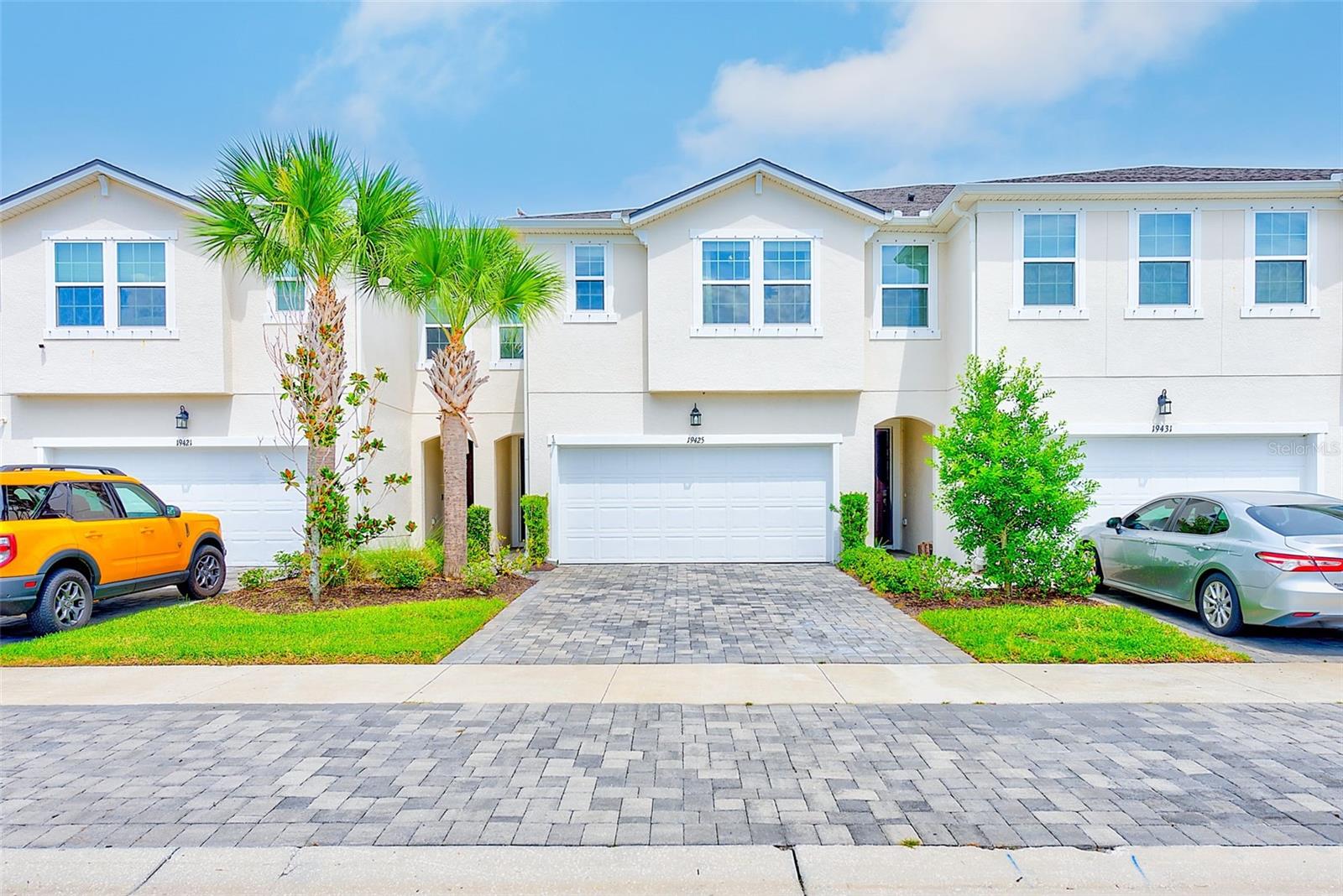 Welcome to this stunning 2022-built townhome offering 3 bedrooms, 2.5 bathrooms, a spacious 2-car garage, and 2,243 square feet of thoughtfully designed living space. This home has been beautifully upgraded with fresh interior paint, 5” baseboards throughout, custom-trimmed windows, and updated light and faucet fixtures, creating a stylish and move-in-ready atmosphere.
The main level features an open floor plan where the dining area, kitchen, and living room flow seamlessly together. Large 3-panel sliding doors flood the space with natural light and open to a paved and enclosed back patio, perfect for entertaining or relaxing outdoors. The chef’s kitchen is equipped with solid wood cabinetry, quartz countertops, stainless steel appliances, a breakfast bar, and a walk-in pantry. Just off the kitchen, you’ll find a custom-built mud area with a storage bench, coat hooks, and floating shelving for convenience. The living room is enhanced with a custom-built electric fireplace featuring a shiplap front, built-in storage, and wood floating shelves that add warmth and charm. For added functionality, a downstairs half bathroom and a storage closet off the living room make everyday living easy and organized.
Upstairs, the split floor plan centers around a large family room and includes a convenient laundry room. The primary suite is a true retreat, offering two walk-in closets and an ensuite bathroom with dual quartz vanities, a spacious standing shower, linen closet, and private commode. On the opposite side, two additional bedrooms each feature walk-in closets. One secondary bedroom has been beautifully designed with wood slat accents, wallpaper, and a rattan light fixture, creating a stylish and unique space. A full bathroom with modern finishes serves the secondary bedrooms.
Located in the heart of Lutz, FL, within one of the most desirable communities in Tampa Bay—Parkview at Long Lake Ranch—this home offers access to incredible amenities, nearby shopping, dining, and top-rated schools. Parkview at Long Lake Ranch is zoned for A-rated schools including Oakstead Elementary School, Rushe Middle School, and Sunlake High School. This gated community features a resort-style pool, dog park, and two playgrounds, while being just minutes from brand-new restaurants, and shopping destinations. With quick access to major highways, commuting to Tampa International Airport, downtown Tampa, and Florida’s world-famous beaches—including Clearwater Beach and St. Pete Beach—is a breeze.
This gem won’t last long! Schedule your showing today and experience the best of Lutz living!