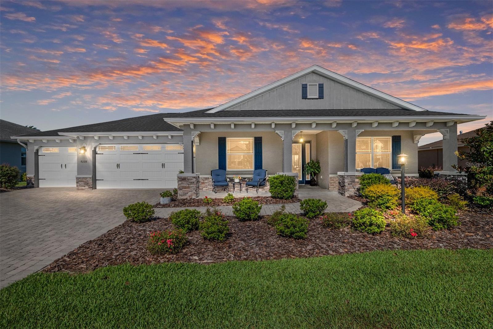 Absolutely stunning Arlington model home located in the desirable Larkhill section of Candler Hills West in On Top of the World! This home has amazing curb appeal... you will notice the beautiful paver driveway and sidewalk leading you past the lush landscaping and to the welcoming, large covered front porch entrance. This 3-bedroom, 3 bath home features an extended 3-car garage (1077 sqft) with golf cart/workshop space and has plenty of room for storage. Upon entering this lovely home you'll notice the spacious foyer is enhanced by an upgraded tray ceiling creating a grand entrance to the beautifully designed open concept, great room and gourmet kitchen which features many upgrades including staggered cabinets, slide out drawers, a touch free kitchen faucet, 10 ft. center Island with interior cabinets, tile backsplash, quartz countertops, a full length pantry cabinet with pull-out shelving for easy access and plenty of storage, built in oven and microwave combo, recessed lighting, pendants and under cabinet lighting, a gas range cooktop, lots of counter space throughout kitchen and stainless-steel appliances. The large L-shaped lanai and patio steal the show... the lanai is adorned with floor-to-ceiling, insulated, glass sliding doors all along the full length of the lanai which offers a full panoramic view of the golf course! This three-season lanai is the perfect place to unwind and relax, watch the sunset and entertain. The back paver patio with custom BBQ peninsula offers an elegant outdoor space to entertain as well. Other features include St Augustine grass in both front and back of the home, rain gutters front and back and added cabinets for storage in both the laundry room and garage. The Large and MiniMax Big Green Egg grills, the matching loveseat and chairs on the front porch AND the golf cart are INCLUDED in the sale of this amazing home. The Larkhill neighborhood of Candler Hills exclusively offers over-sized lots nestled in the Candler Hills community of On Top of the World with incredible golf course views of Candler Hills Golf Course. On Top of the World is Ocala's premier, gated, active 55+ community, loaded with amenities and includes golf cart access to three shopping centers.