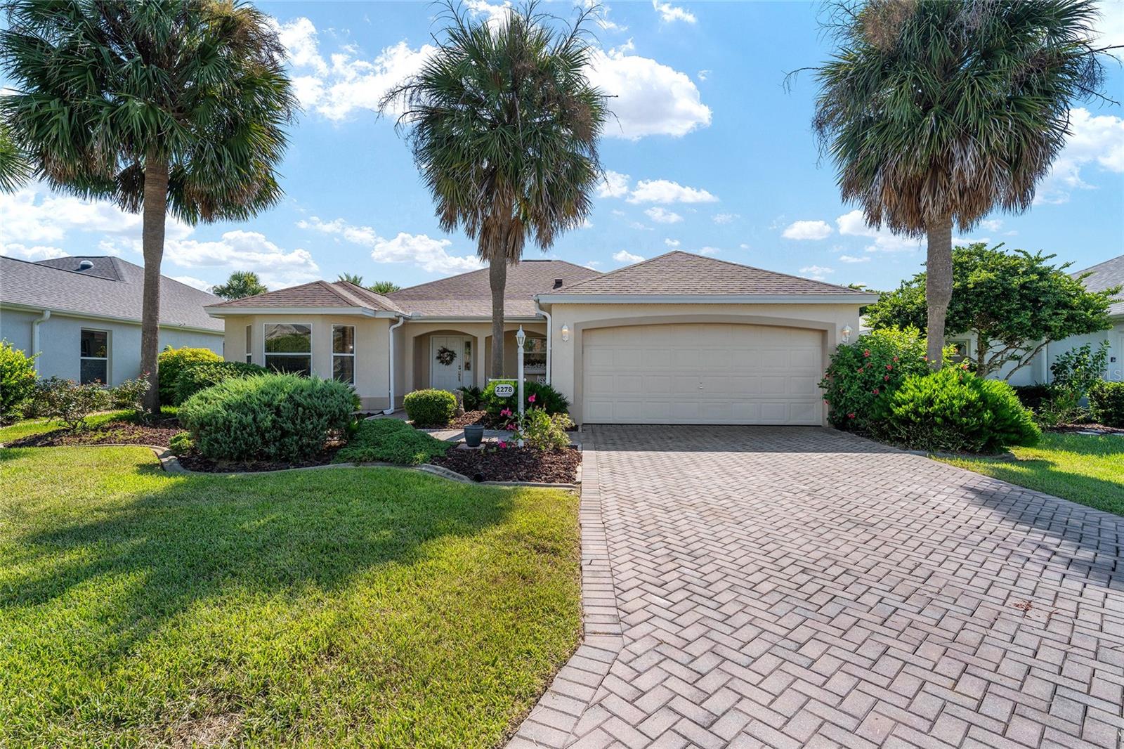 You are not going to believe how nice this home is and with so many extras and upgrades! This VERA CRUZ model, over 2000 SF, in the Village of SANTO DOMINGO has been lovingly renovated and staged to be the perfect home or investment with NO BOND! The extras include Extensive wide CROWN MOULDING, decorative niches, ROOF OCT. 2022, newer HWH, a large solar tube for brightness, ALL NEW FIXTURES AND FANS, a FLORIDA ROOM, plus a LARGE SCREENED PORCH, and large backyard with Wall for PRIVACY!
Nicely landscaped and a brick paver driveway lead to an inviting covered front porch. As you enter the foyer you notice the beautiful light LUXURY VINYL PLANK flooring throughout, the soothing colors and the open floor plan. And a HALL CLOSET! The kitchen, on your left, is bright and large featuring newer STAINLESS STEEL appliances (2023) QUARTZ COUNTERS and stunning BACKSPLASH, a Double WALL OVEN, Deep SS Sink, Coffee Bar area, large counter with storage, an Eat In area with large windows overlooking the front yard, and storage galore with pull out cabinets
The laundry room is across the hall with the same beautiful Quartz counters, newer W/D and storage! It leads to the EXPANDED GARAGE with storage, attic stairs and attic decking. The open Living/Dining room is so inviting with plenty of room for entertaining and relaxing. It looks onto the Florida Room which has so many uses- extra sleeping, office, reading! It leads to the screened outside area which overlooks the large back yard. An Amazing Space! The bedrooms are separated for privacy with the large Owner's suite having two walk-in closets! One in the bedroom and one very large storage closet in the en-suite which has also been renovated with the same Quartz counters, new toilets and sinks. It's just so nice! The guest wing is on the other side of the living room and features two rooms with closets with a full bath between the rooms which has also been renovated with Quartz counter, new fixtures, mirror and toilet.
This home was an investment property and did really well as a seasonal rental. It is in a wonderful location - a short golf cart ride to Spanish Springs or Lake Sumter Landing Squares as well as shopping, dining, golfing, recreation centers and pools! Many of the furnishings, which are exquisite, are available as a separate purchase. With full asking price, the seller will replace the current HVAC and provide a painted epoxy garage floor. Otherwise the seller will provide a whole house Replacement WARRANTY for peace of mind. Please call to schedule your private showing- you won't be disappointed!!
